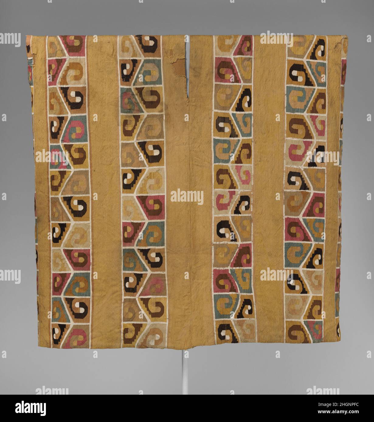 Tapestry Tunic 7th–9th Century Wari la regione andina del Sudamerica fu sede di una delle più lunghe e complesse storie tessili del mondo. Tra le tradizioni più spettacolari c'è quella dell'Impero Wari. Dalla loro capitale altoatesina, vicino all'attuale Ayacucho, i Wari esercitarono una forte influenza politica e culturale sulle regioni costiere e altoatesine meridionali del Perù. Introdussero uno stile d'arte distintivo, che si trova su raffinate ceramiche policrome, squisiti ornamenti personali fatti di materiali preziosi, sapientemente scolpiti opere in legno, conchiglie e pietra, e soprattutto su tessuti elaborati. Foto Stock