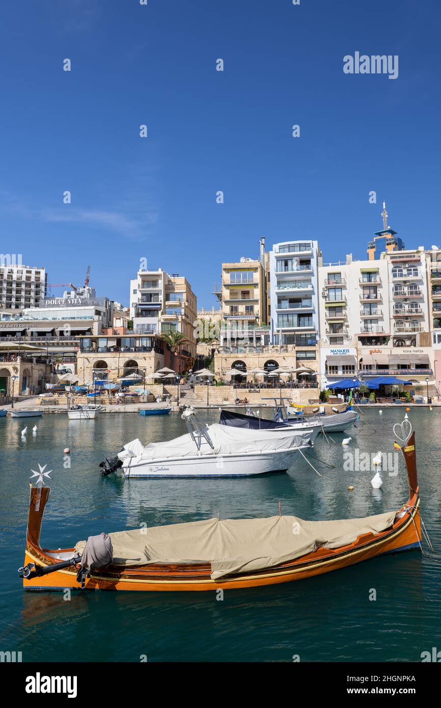 Città di San Giuliano (maltese: San Ġiljan) a Malta, condomini e barche nella baia di Spinola. Foto Stock