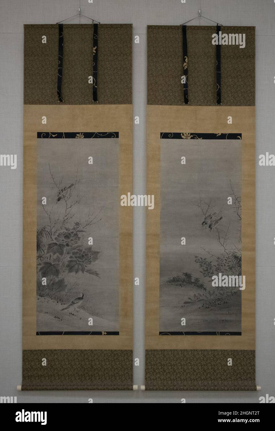 Uccelli e fiori metà del 16th secolo attribuito a Kano Yukinobu 狩野之信 giapponese nei monasteri di Zen, icone sacre sono state talvolta visualizzate affiancate da soggetti complementari, apparentemente secolari come uccelli, fiori o paesaggi. Trittici di rotoli combinati in questo modo potrebbero sposare dipinti cinesi e giapponesi o opere create in tempi diversi o in mezzi di comunicazione diversi. In questa configurazione, l'icona centrale immagina il bodhisattva di Kannon bianco nel suo paradiso, visitato da un giovane pellegrino chiamato Zenzai Dōji. È accompagnato da un dittico più tardi creato da un artista professionale affi Foto Stock
