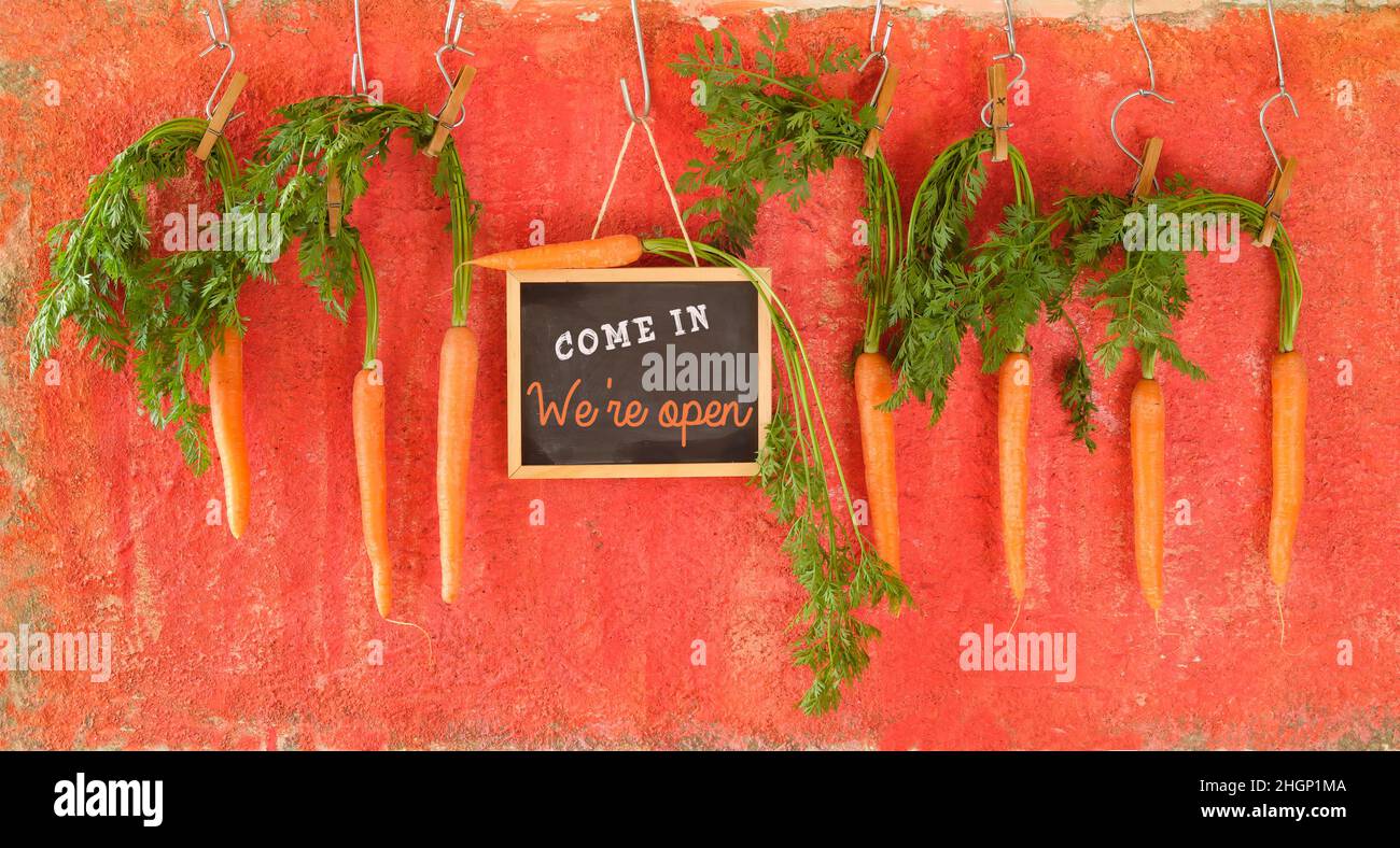 Ristorante open sign con carote appese, messaggio di riapertura dopo il blocco corona, concetto di gastronomia business. Foto Stock