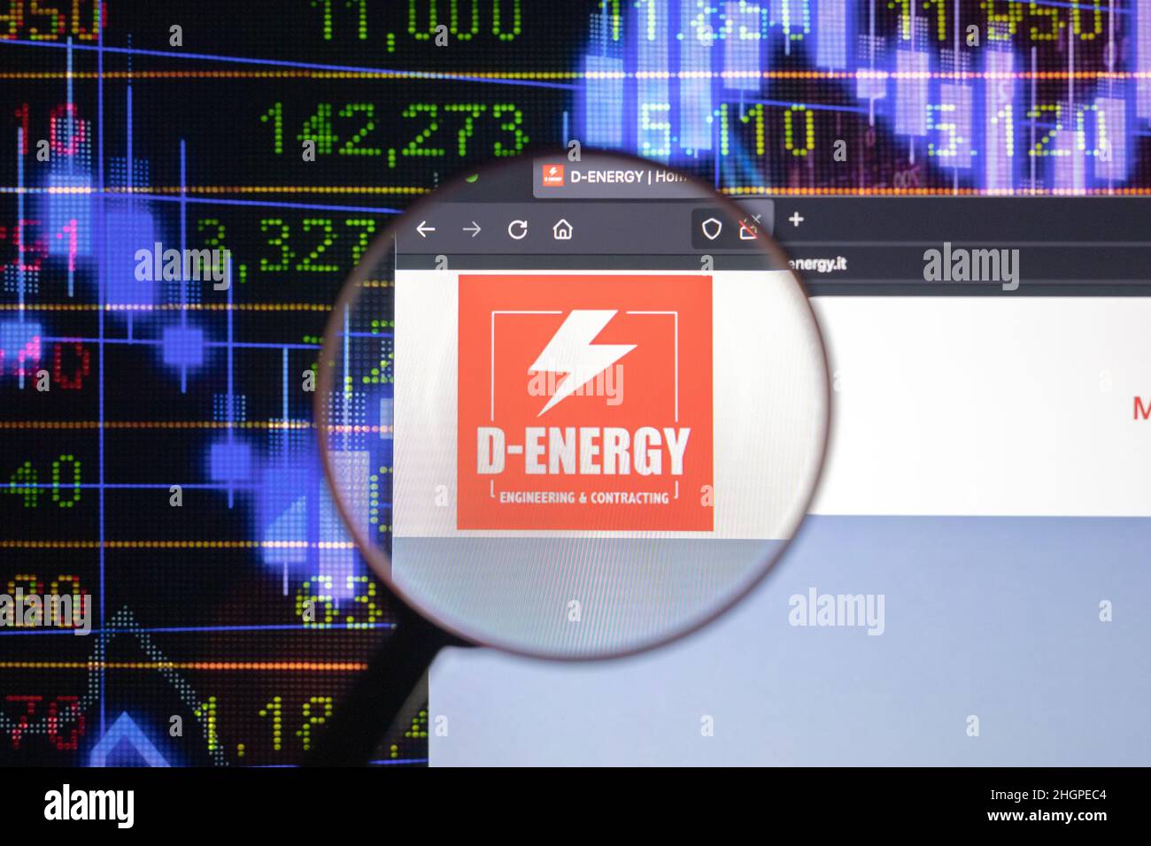 D-Energy logo aziendale su un sito web con blurry sviluppi del mercato azionario in background, visto su uno schermo del computer attraverso una lente d'ingrandimento. Foto Stock