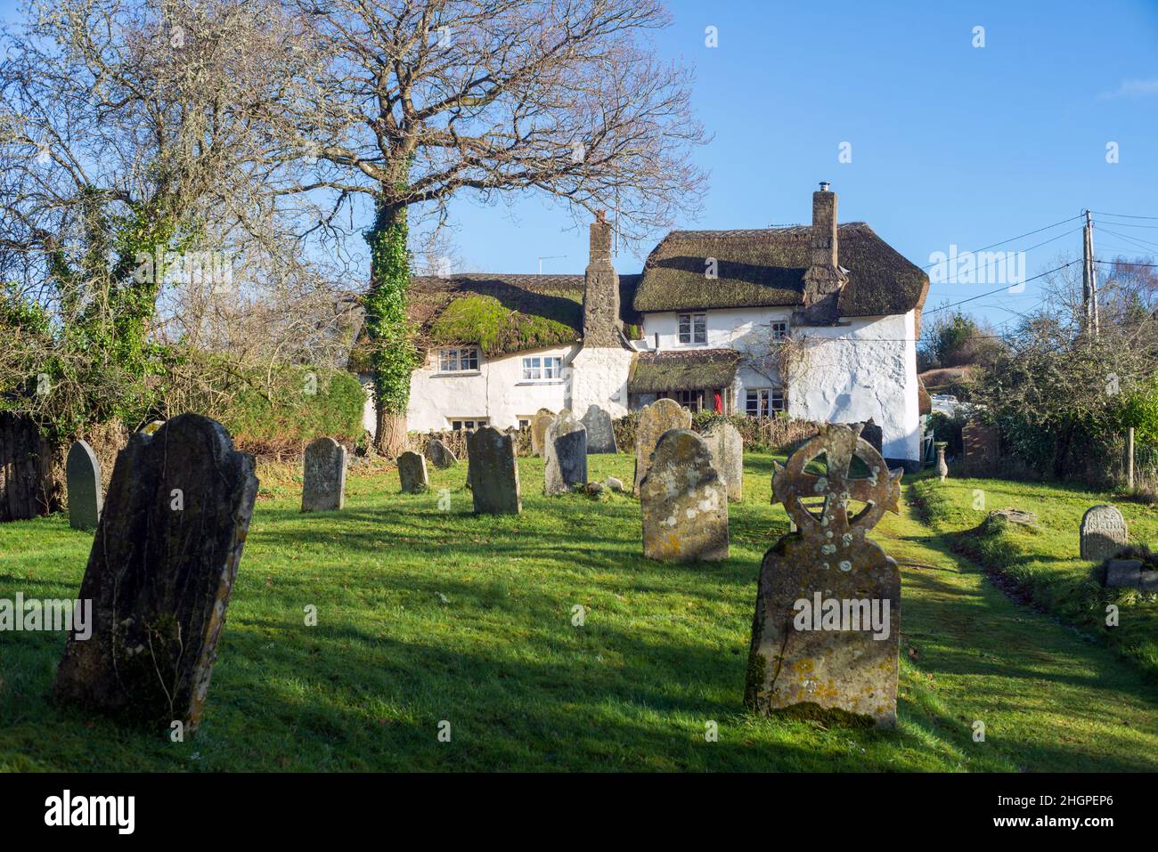 Regno Unito, Inghilterra, Devon. Ashton più alto sulle pendici della valle di Teign. Chiesa di San Giovanni Battista cimitero e villaggio cotteges paglia. Foto Stock