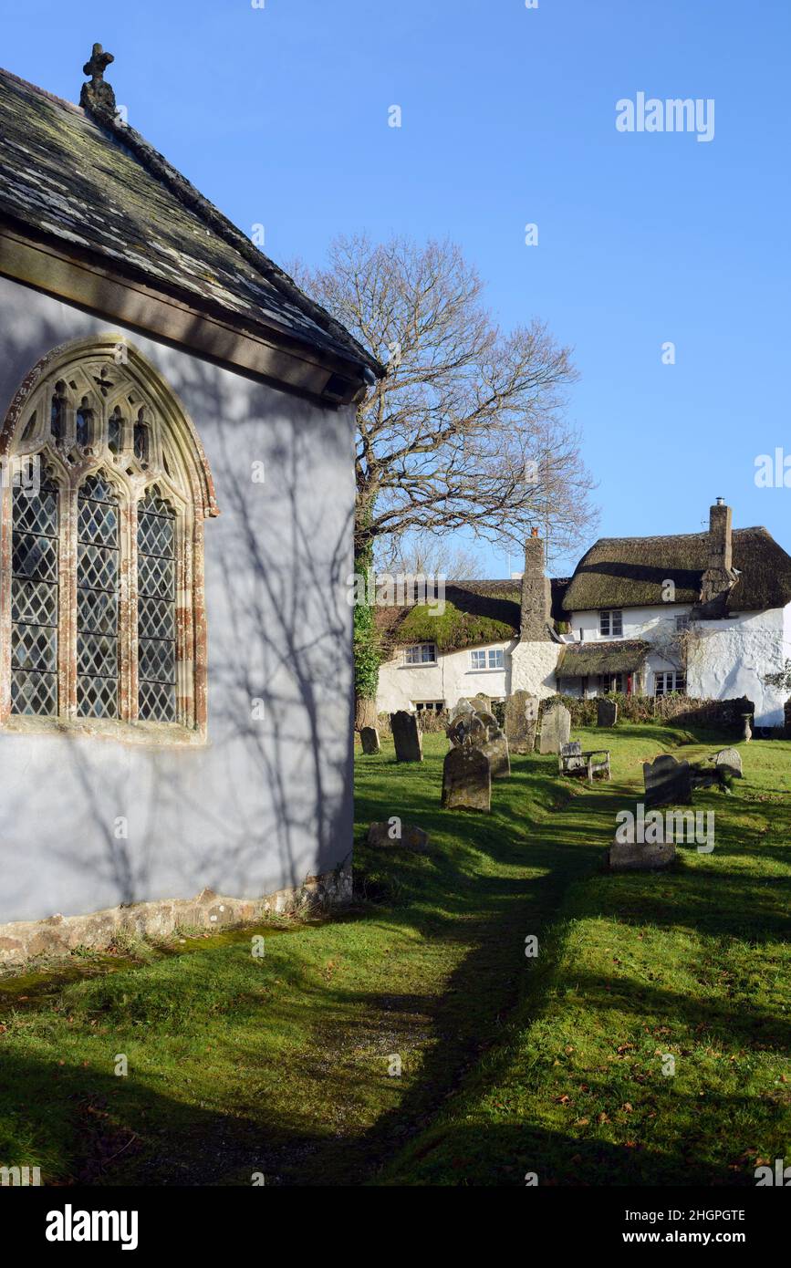 Regno Unito, Inghilterra, Devon. Ashton più alto sulle pendici della valle di Teign. Chiesa di San Giovanni Battista, cimitero e case di paglia villaggio. Foto Stock