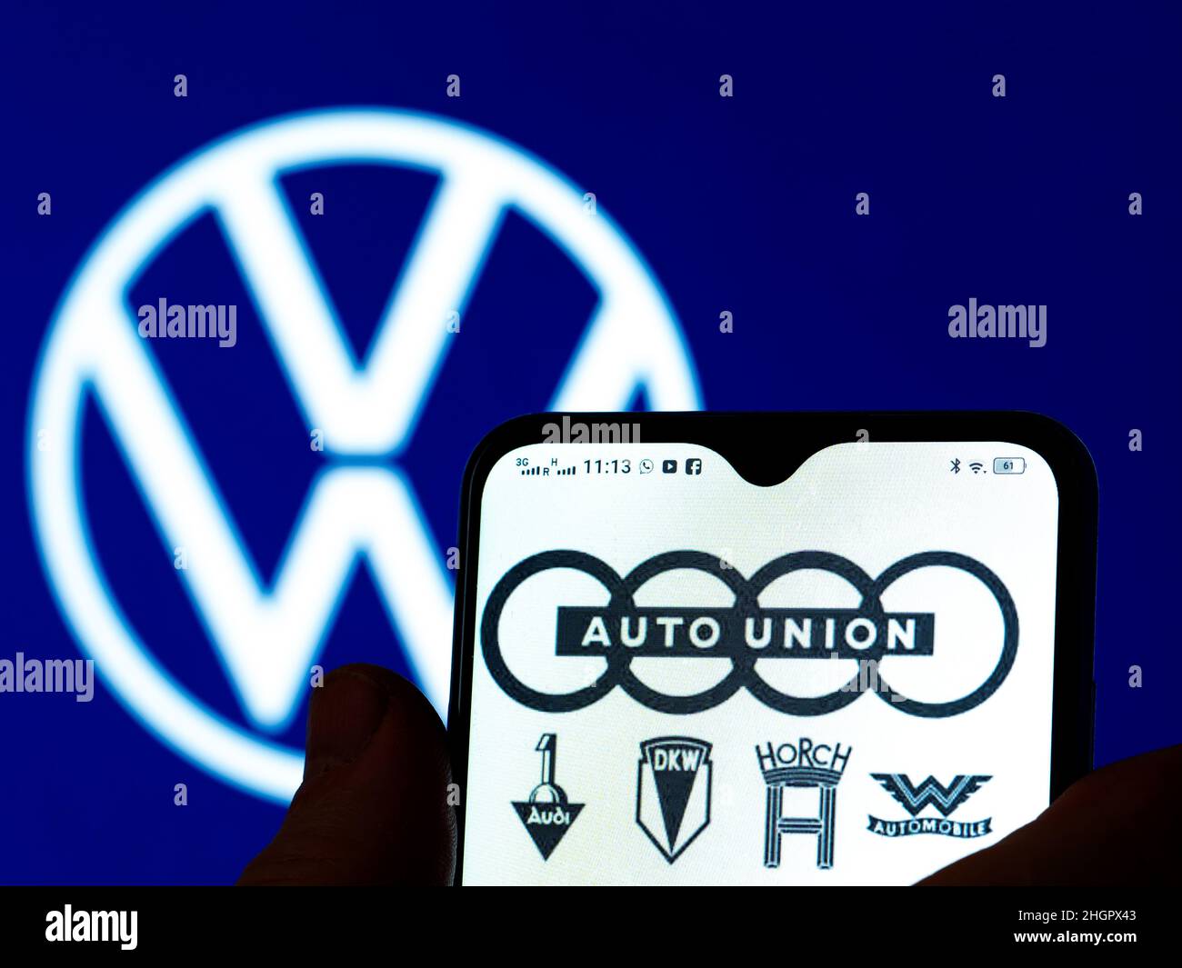 In questa foto, il logo Auto Union AG viene visualizzato sullo schermo di uno smartphone con il logo Volkswagen AG sullo sfondo. Foto Stock