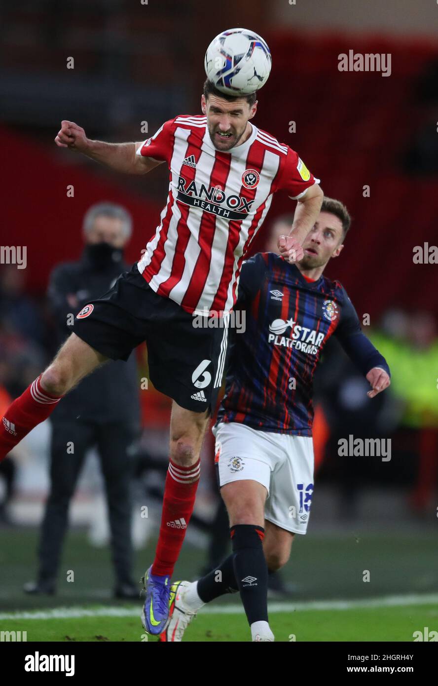Sheffield, Inghilterra, 22nd gennaio 2022. Chris Basham di Sheffield Utd si trova davanti a Jordan Clarke di Luton Town per vincere la testa durante la partita del campionato Sky Bet a Bramall Lane, Sheffield. Il credito dovrebbe essere: Simon Bellis / Sportimage Foto Stock