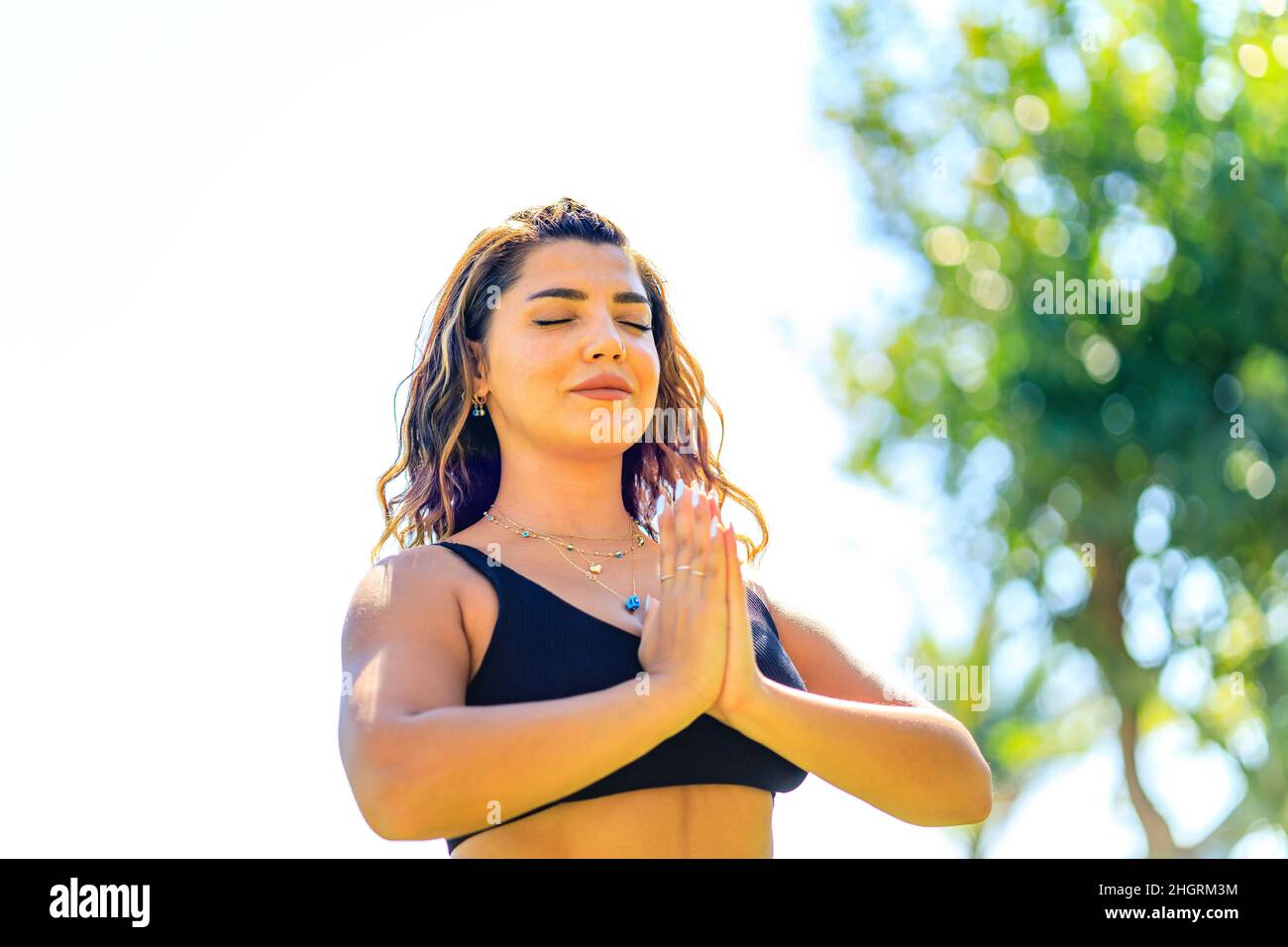 Giovane donna indiana attraente praticare yoga , profonda calma respirando all'aperto nel parco verde estivo Foto Stock