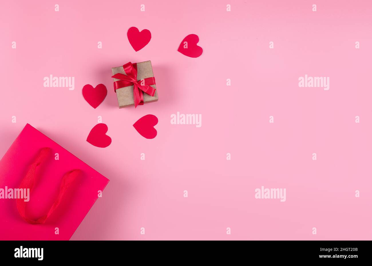 Concetto di shopping online. Vista dall'alto della borsa regalo e dei cuori di carta rosa Foto Stock