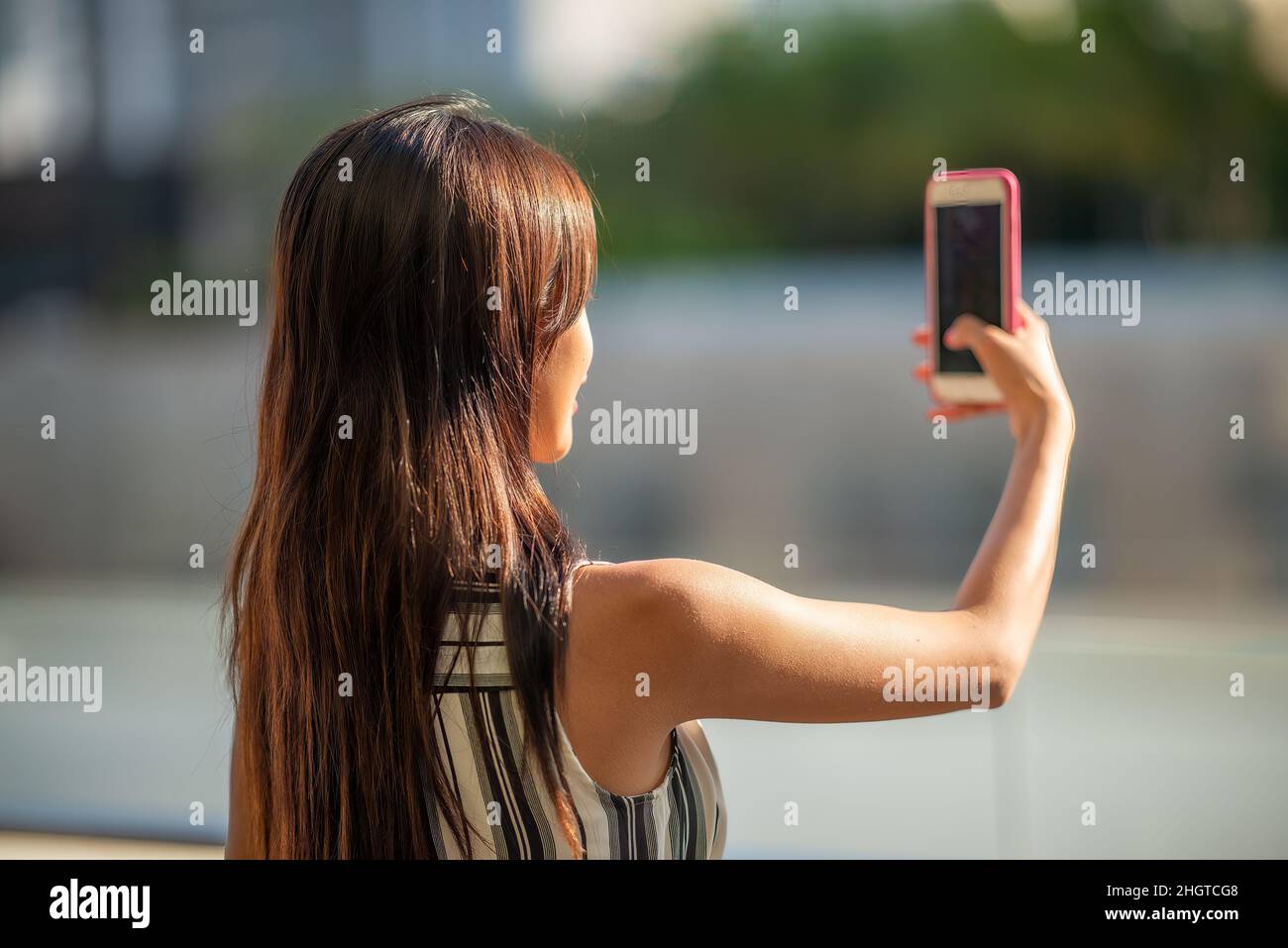 Donna d'affari asiatica che prende selfie con smartphone all'aperto Foto Stock