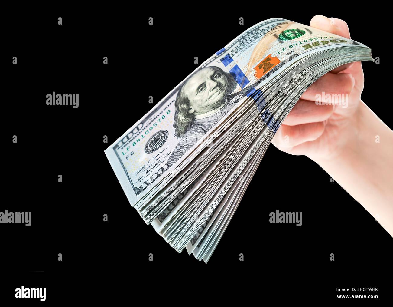 Mano con pila di cento dollari americani fatture su sfondo nero Foto Stock