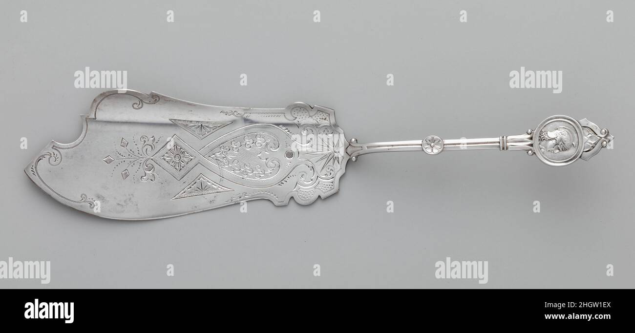 Fetta di pesce ca. 1872 Schulz & Fischer la metà del diciannovesimo secolo è stata testimone di un’efflorescenza della creatività nell’industria dell’argento americana, alimentata dalla crescente domanda della classe media di beni di lusso raffinati. Gli argentini dedicavano tempo considerevole ed energia creativa alla generazione di una varietà infinita di nuovi disegni e modelli. Nel corso del 1860s e del 1870s le fioriere d'argento ornate con medaglioni di ritratto ispirati a monete antiche e cammei godevano di una popolarità diffusa, con quasi tutti gli argentini americani che producevano il proprio modello di 'medaglione' proprietario. Questa fetta di pesce Foto Stock