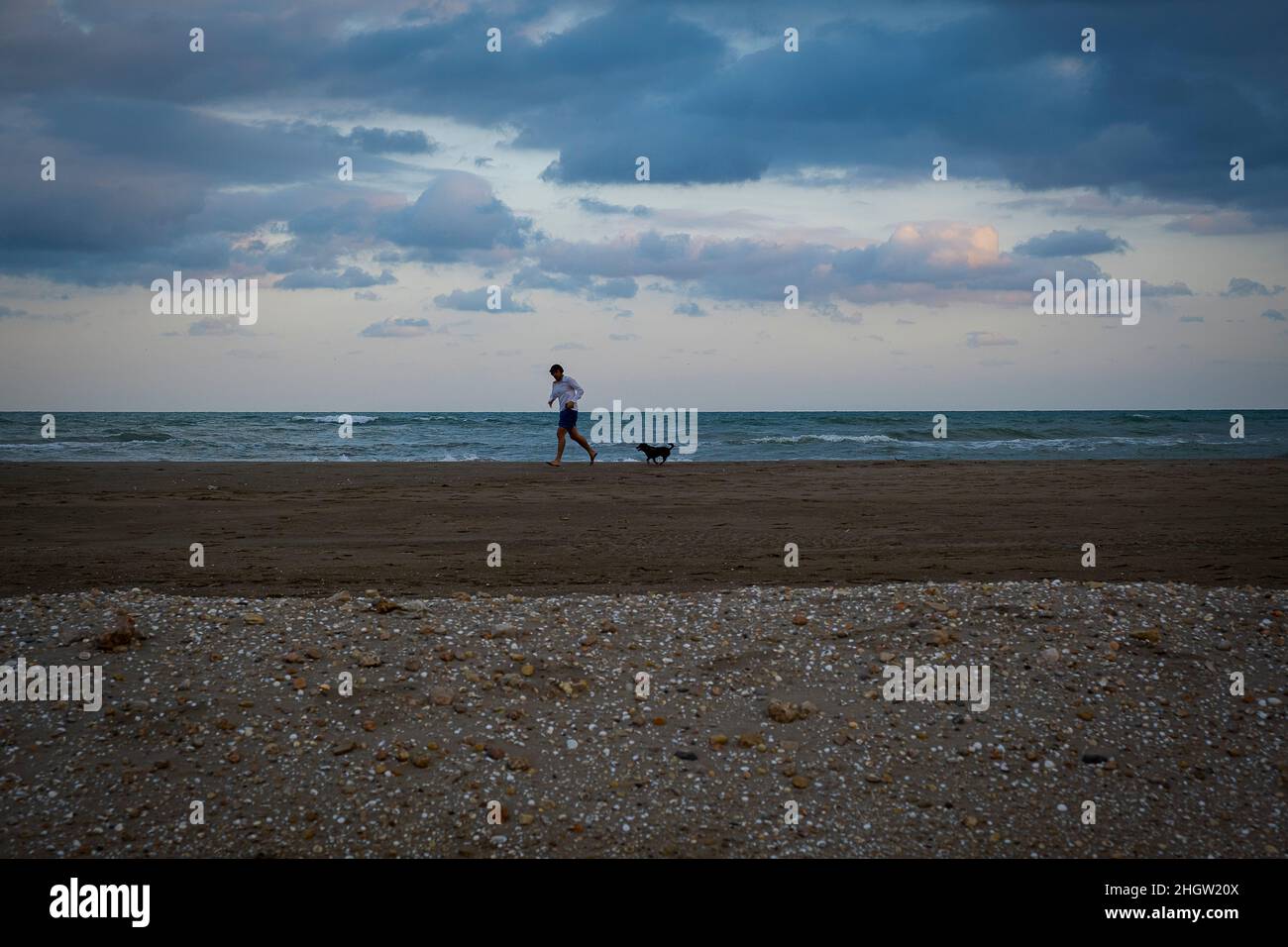 Uomo in corsa, sulla spiaggia di El Trabucador, Sant Carles de la Rapita, Delta dell'Ebro, Parco Naturale, Tarragona, Spagna Foto Stock