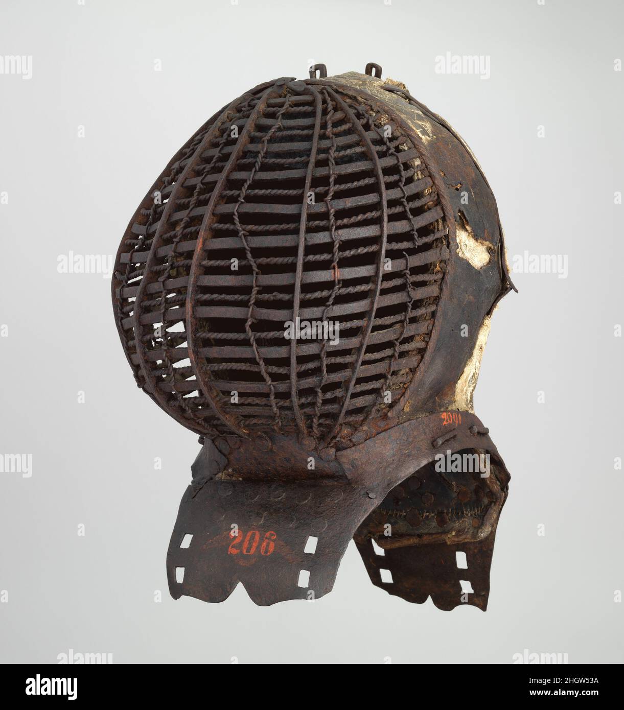Torneo Helm (Kolbenturnierhelm) 1450–1500 Tedesco questo casco estremamente raro è stato destinato al torneo combattuto da gruppi di combattenti montati armati di club (Kolben) o spade blunted. Il casco è formato da una struttura in ferro ricoperta di tela e gesso impresso da un disegno floreale basato su motivi tessili. A causa della natura fragile della decorazione del gesso rialzato, pochissimi di questi caschi sopravvivono. Sul retro si trova lo stemma della famiglia von Stein, che qui appare come tre trappole di lupo nero su uno scudo bianco. Torneo Helm (Kolbenturnierhelm). Tedesco. 1450–1500. Ste Foto Stock