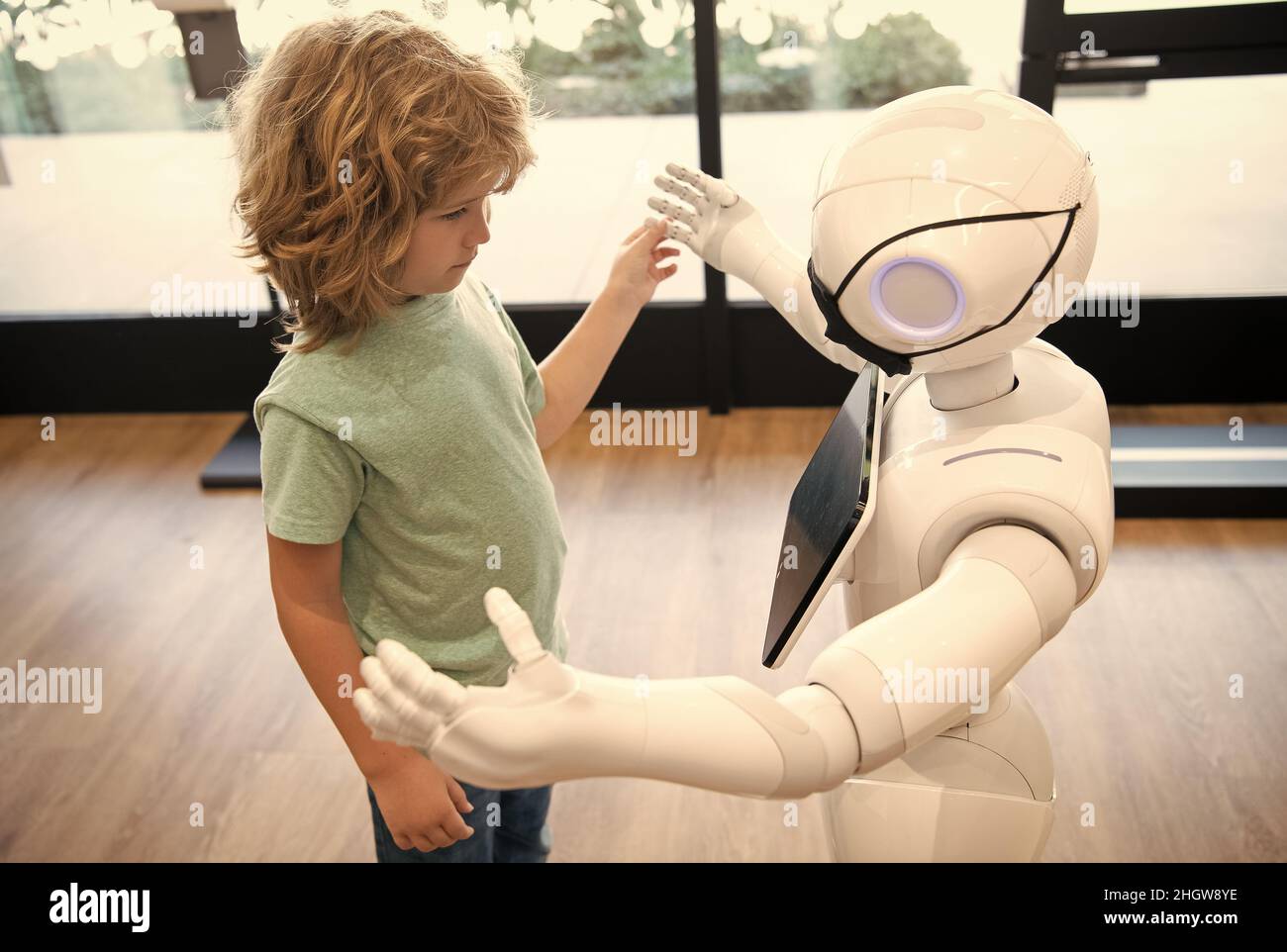 futuro pandemico robotico. il robot comunica con il bambino. automazione. tecnologia umanoide Foto Stock