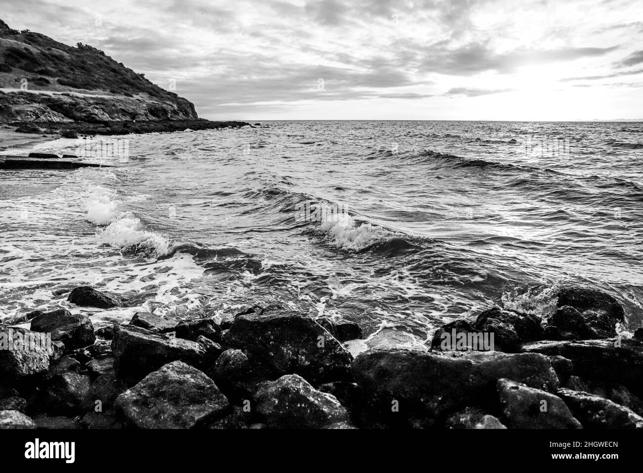 Schiuma delle onde di mare che si infrangono tra le rocce al tramonto sui resti di un vecchio molo di pietra a nord di Bahia Kino. Kino Bay nello stato di sonora M. Foto Stock