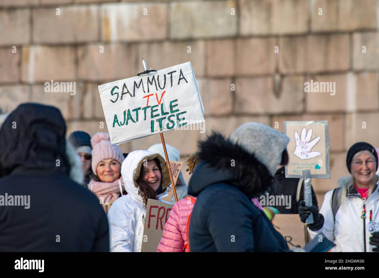 Persone con segni scritti a mano che protestano contro le restrizioni del virus corona in Piazza del Senato a Helsinki, Finlandia Foto Stock