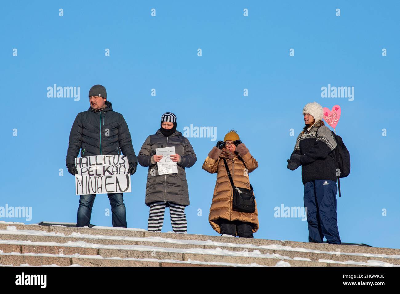 Manifestanti con cartelli sulla sommità dei gradini della Cattedrale di Helsinki a dimostrazione contro le restrizioni corona a Helsinki, Finlandia Foto Stock