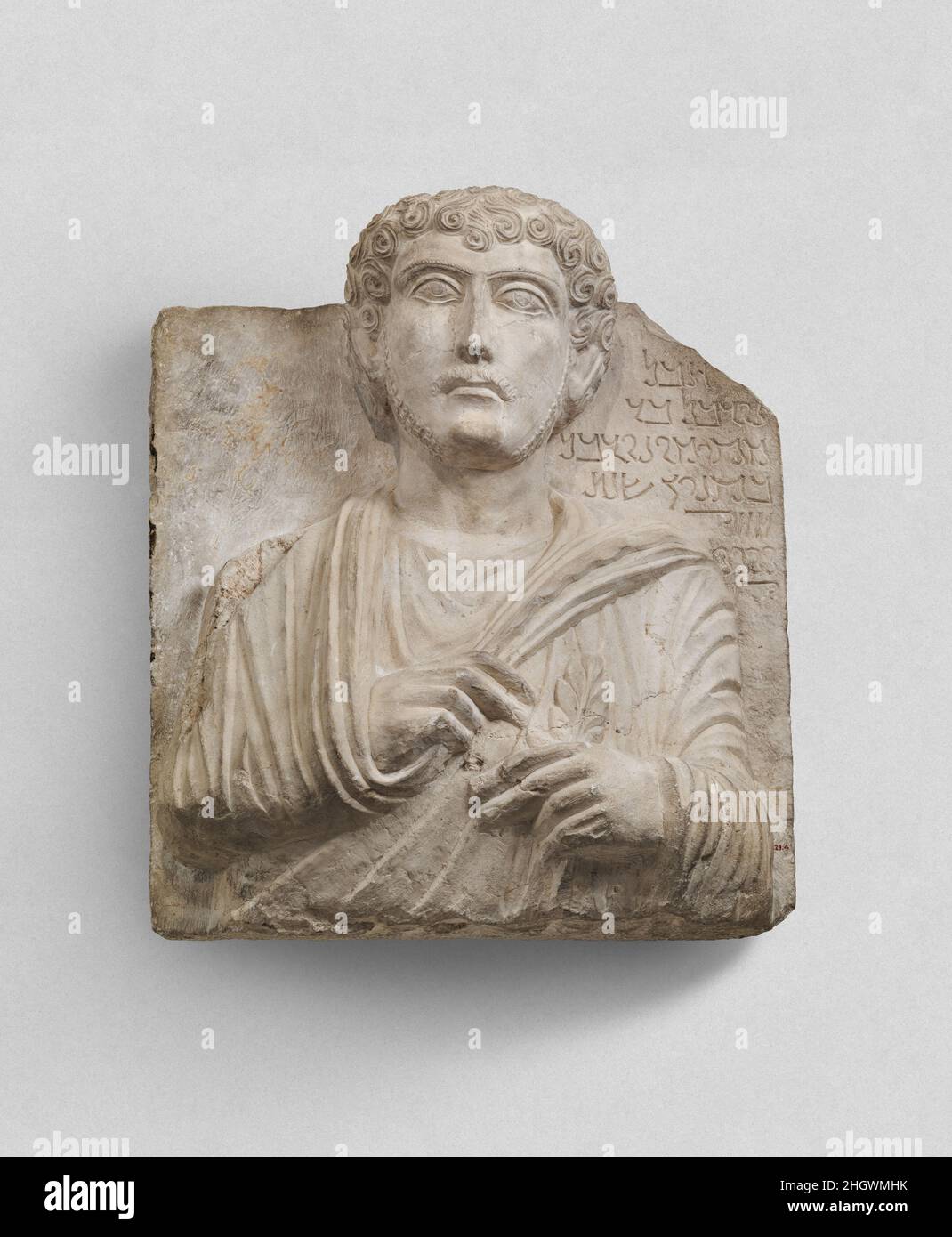 Rilievo funerario ca. 181 Iscrizione:1 Alas! 2 Nurbel, figlio di 3 Mokimu, figlio di Nurbel. 4 nel (il mese di) Qinyan, L'anno 5-7 492.Translitteration:1 ?BL2 nwrbl BR3 mqymw nwrbl4 bqnyn šnt5 4,1006 +807 +10+2This rilievo è un tipo di monumento funerario caratteristico della prospera città carovana di Palmyra durante i primi tre secoli A.D. rilievi con una rappresentazione del defunto e una breve iscrizione identificativa sono stati usati a. Le nicchie di sepoltura del sigillo in tombe comunali decorate in modo elaborato; quelle con un formato di mezza lunghezza o di busto divennero prevalenti qualche volta dopo il D.A. 65. Il rilievo raffigura Foto Stock