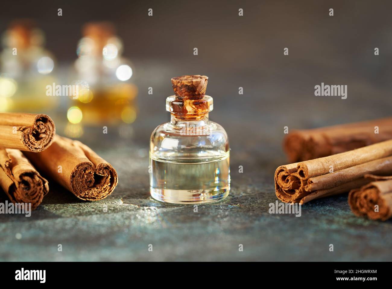 Una bottiglia di olio essenziale aromatherapy con cannella vera o Cinnamomum verum bastoni Foto Stock