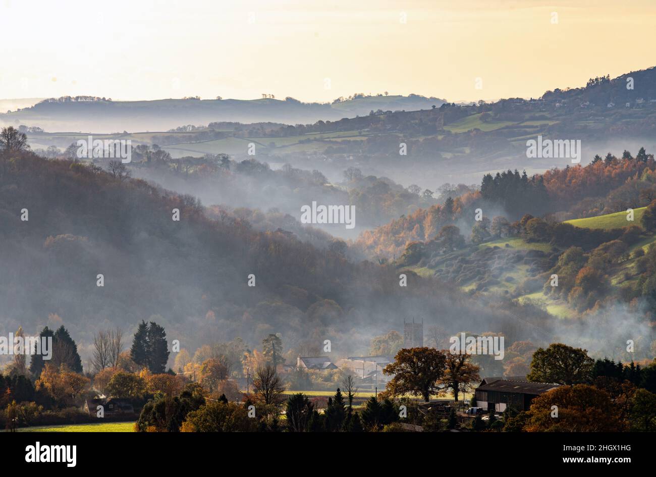 Regno Unito, Inghilterra, Devonshire, la Teign Valley. Doddiscombsleigh villaggio Chiesa. Nebbia e fumo di legno alla luce del mattino. Foto Stock