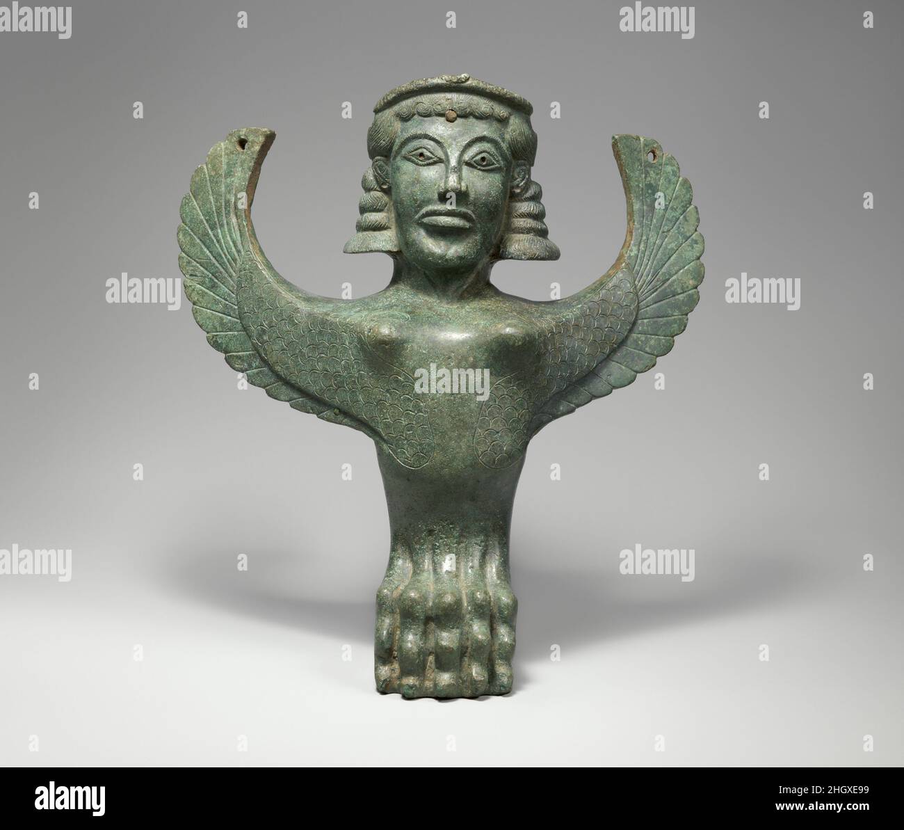 Bronze foot in the form of a sphinx ca. 600 B.C. Greek Between the eighth and sixth centuries B.C., elaborate bronze vessels were among the preeminent creations of Greek artists. This foot was probably one of three supporting an extremely large, shallow basin. Mythological creatures such as the sphinx here and the griffin (1972.118.54) nearby should be understood as guardian figures not simply decoration.. Bronze foot in the form of a sphinx. Greek. ca. 600 B.C.. Bronze. Archaic. Bronzes Foto Stock