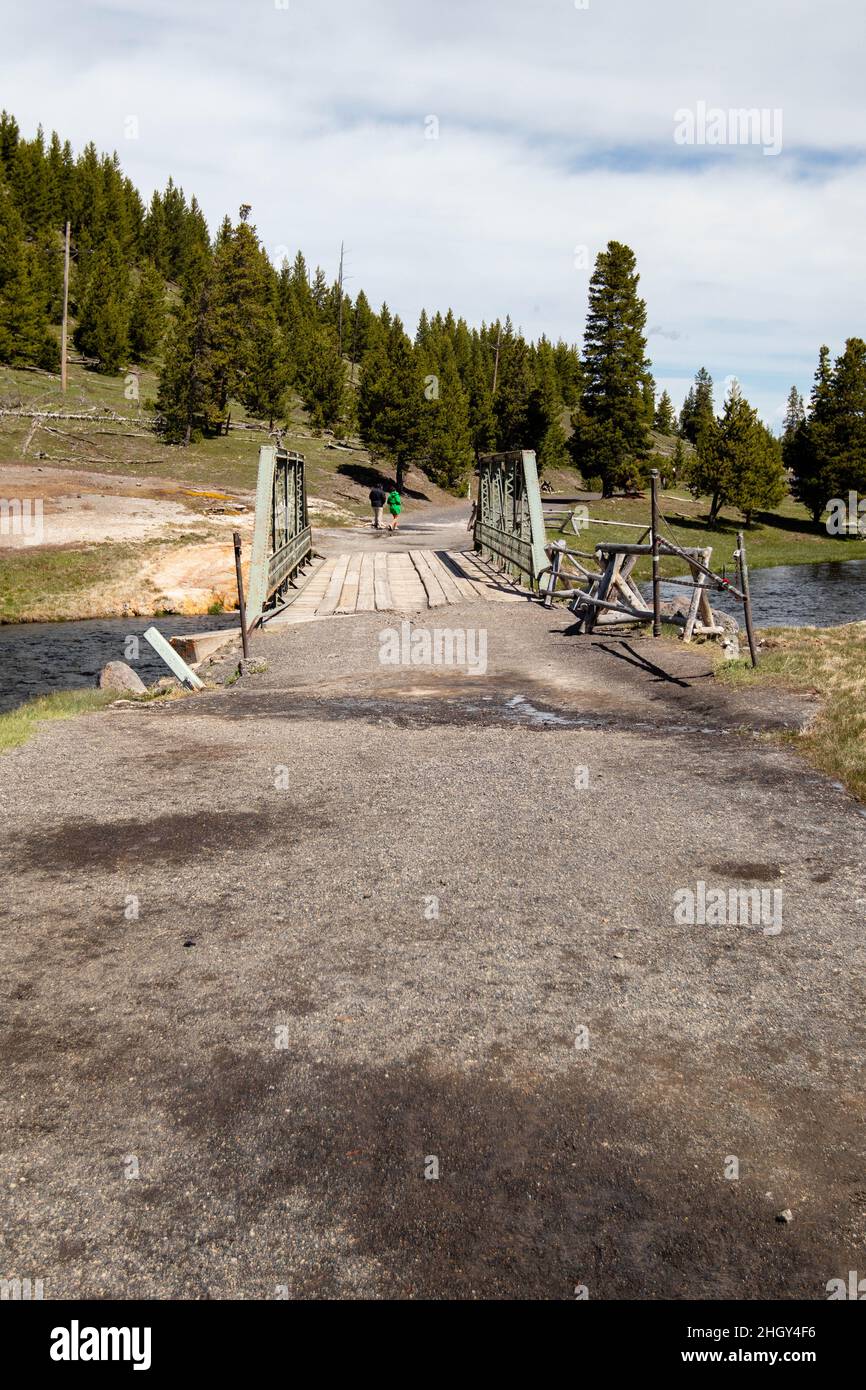 L'inizio del sentiero delle Fairy Falls con un ponte sul fiume Firehole nel parco nazionale di Yellowstone nel Wyoming, in verticale Foto Stock