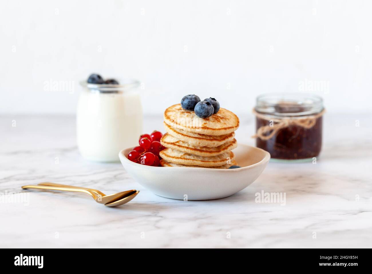 stack di pancake senza glutine decorate con mirtilli e ribes rosso, fuoco selettivo Foto Stock