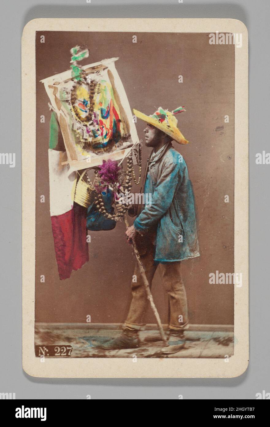 [Studio Ritratto: Man Holding Decorative Stick with Italian Flag, Napoli] 1860s–70s Giorgio Conrad la carta di visite, composta da una stampa di circa 2 x 4 pollici montata su cartoncino, è forse la forma più onnipresente della fotografia del XIX secolo. Dalla fine del 1850s fino alla seconda metà del secolo, questi keepsakes economici circolarono in massa e spronarono una vera e propria “cartomania”. Questo è un esempio di quelli distribuiti dagli studi di fotografia commerciale di Conrad a Napoli e ponti a Venezia, raffiguranti “tipi” professionali legati a quelle città, come ad esempio un cappio Foto Stock