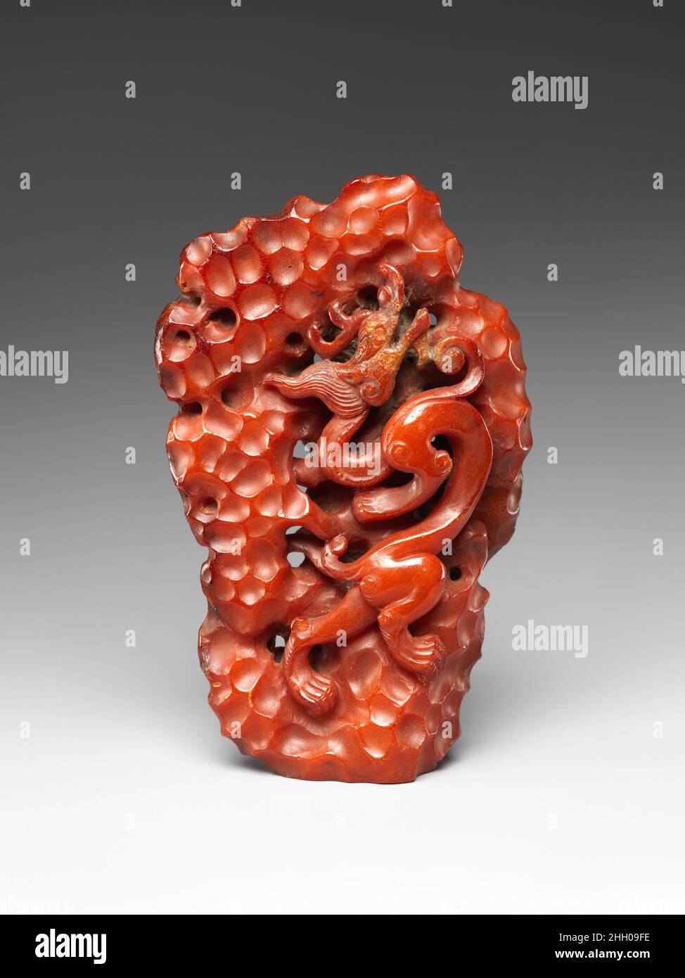 Dragon climbing a rock 14th Century China questa scultura di un drago che si arrampica su un giardino ornamentale di roccia esemplifica il riccamente articolato trattamento scultoreo di materiali preziosi creati durante la dinastia Yuan (1271–1368). Il drago spiritoso illustra la continuazione dell'arte dinamica della dinastia Tang (618-907) nella Cina settentrionale nei secoli successivi. L’ambra, importata dalla Birmania o dall’area baltica, era un materiale particolarmente raro in Cina tranne che durante le dinastie Liao (907-1115), Yuan e Qing (1644-1911), quando il controllo del CE da parte delle case imperiali nomadi Foto Stock