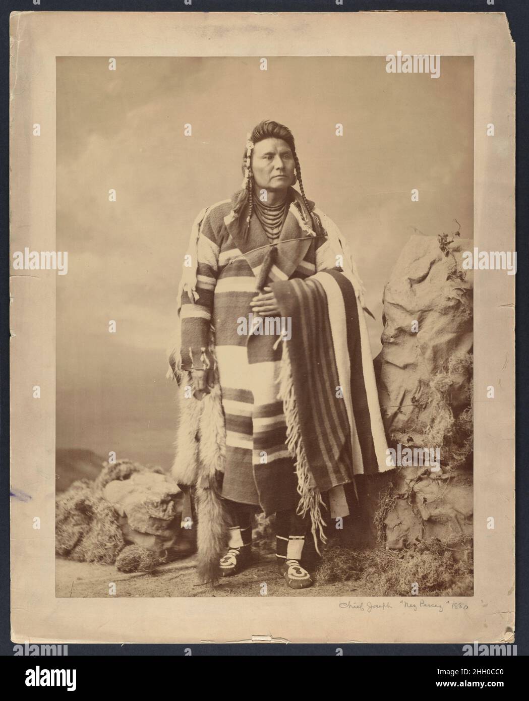 Hinmatóowyalahtq’IT (Chief Joseph) 1879 Charles Milton Bell American nel 1879, mentre forzatamente confinato in una riserva nell'attuale Oklahoma, Hinmatóowyalahtq'IT, O capo Joseph, fu autorizzato a viaggiare a Washington, D.C., dove incontrò il presidente Rutherford B. Hayes e presentò il suo caso per il ritorno del Nez Perce nel Pacifico nord-occidentale. Come era comune per i delegati nativi che visitavano la capitale, posò un ritratto fotografico nello studio di Bell. In piedi in un paesaggio artificiale composto da una roccia papier-mâché, faux muss, e uno sfondo dipinto, il capo Giuseppe guarda nel Foto Stock