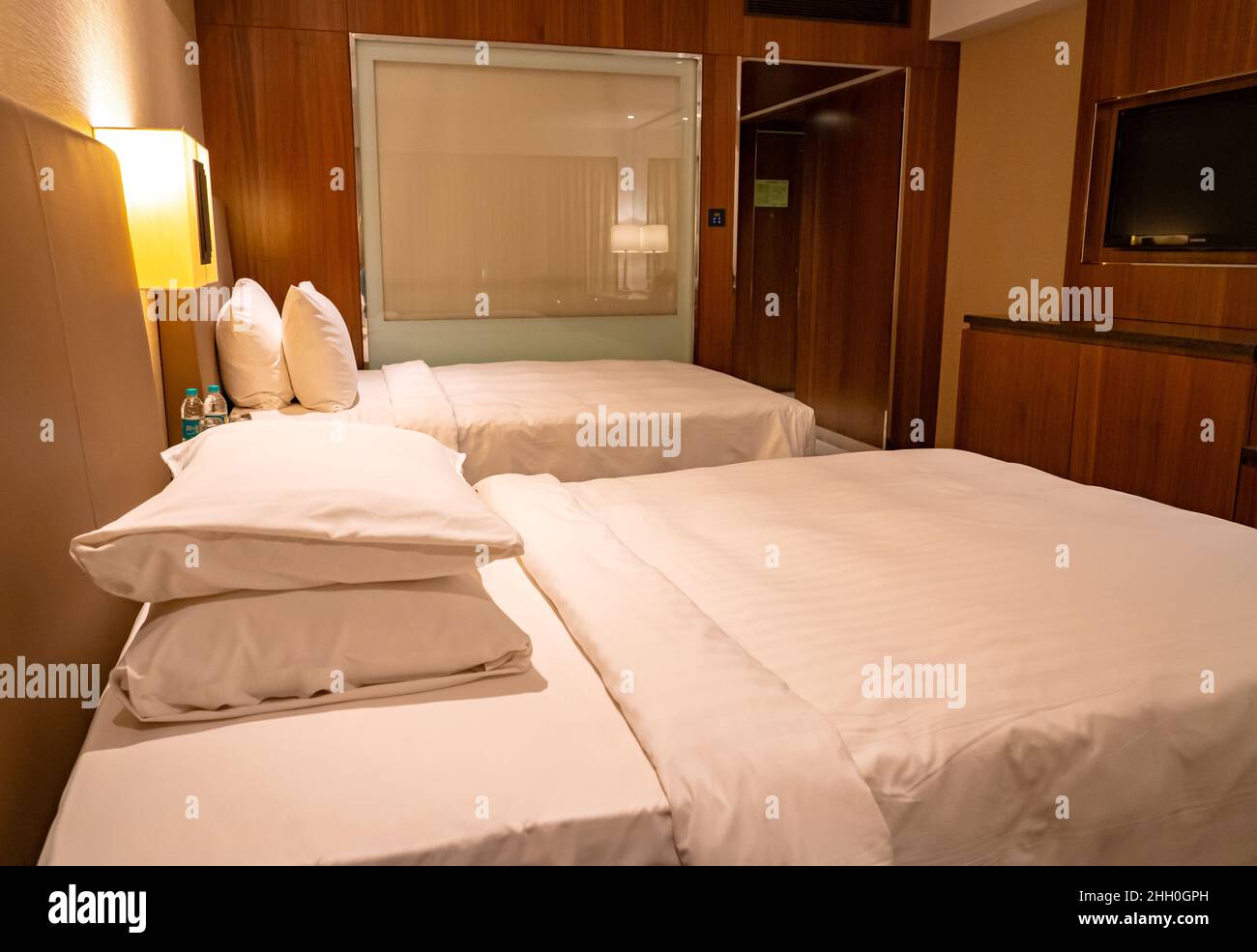 La camera deluxe del Courtyard Marriott Chennai offre due letti gemelli di lusso con spazio e comfort per i viaggiatori d'affari e di piacere. Foto Stock