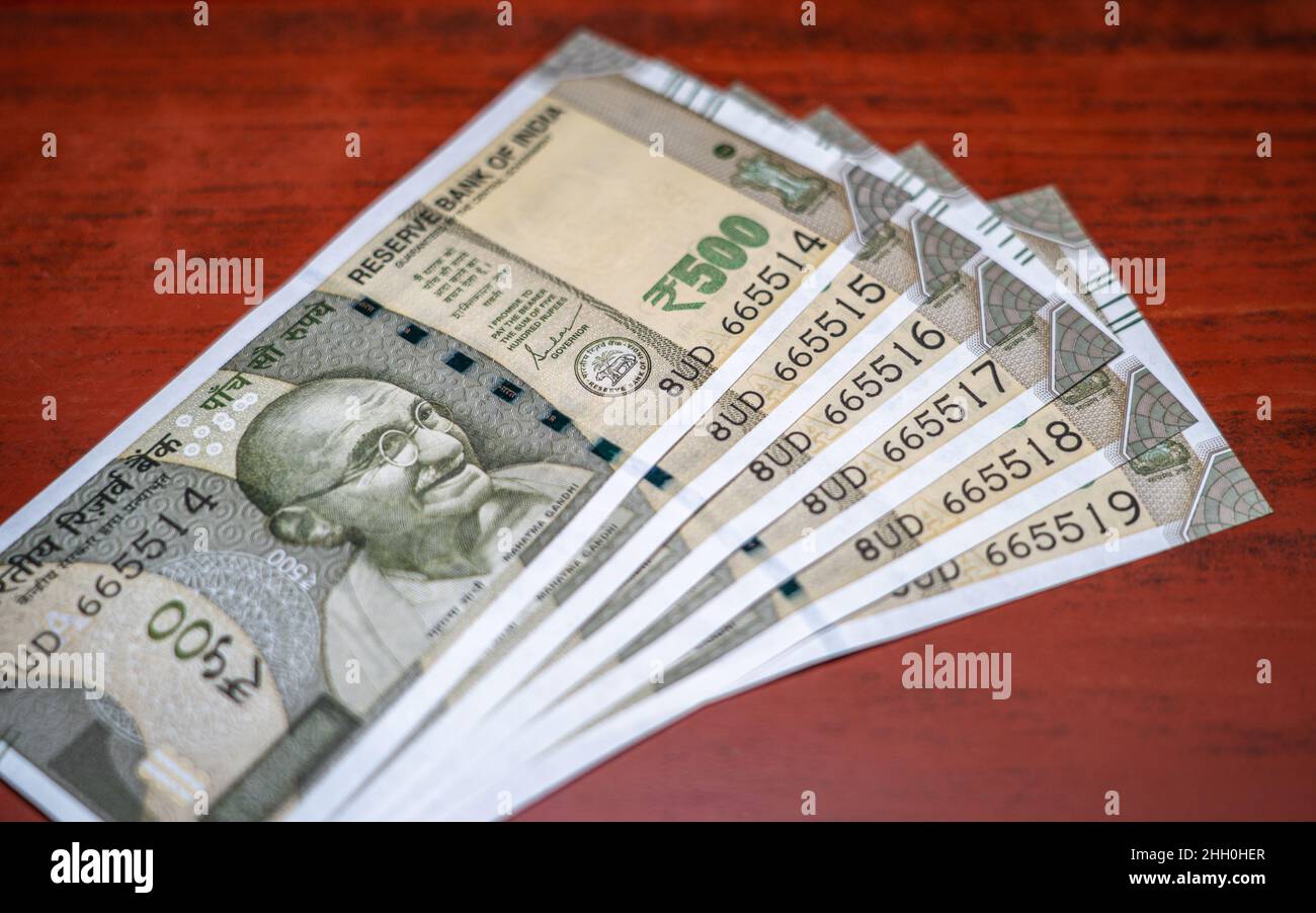 Una serie di cinquecento rupie banconote indiane su sfondo di legno. Foto Stock