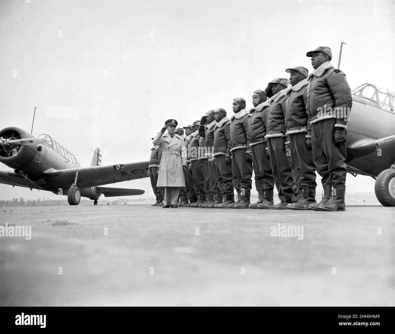 Il maggiore James A. Ellison restituisce il saluto di Mac Ross, mentre recensisce la prima classe di cadetti Tuskegee; alla base del corpo aereo dell'esercito degli Stati Uniti e scuola di volo avanzata, con gli addestratori di Vultee BT-13 nello sfondo, Tuskegee, Alabama, 1941 Foto Stock