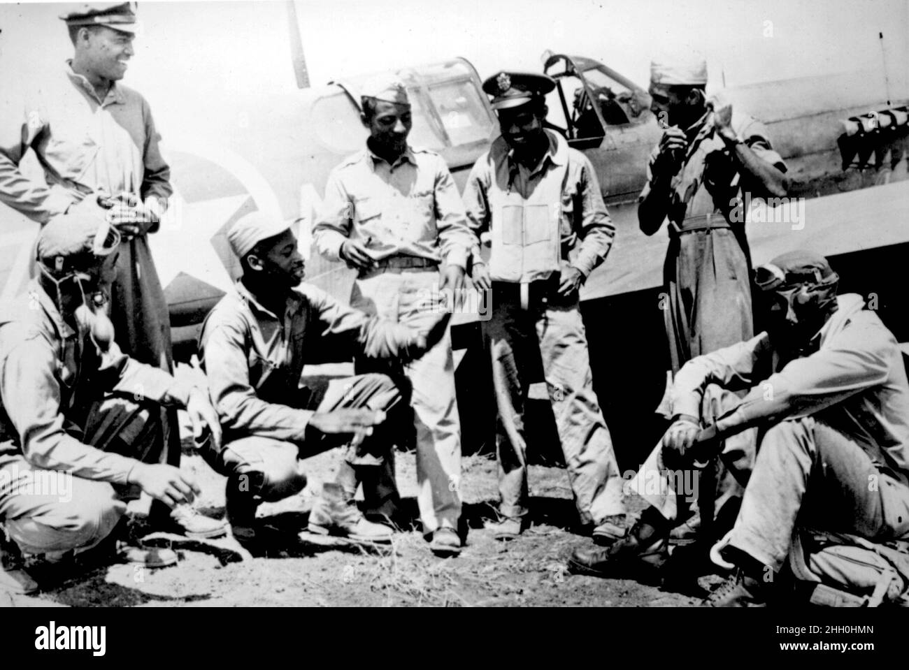 Un gruppo di Tuskeegee Airmen su un campo aereo di un Curtiss P-40 Tomahawk Foto Stock