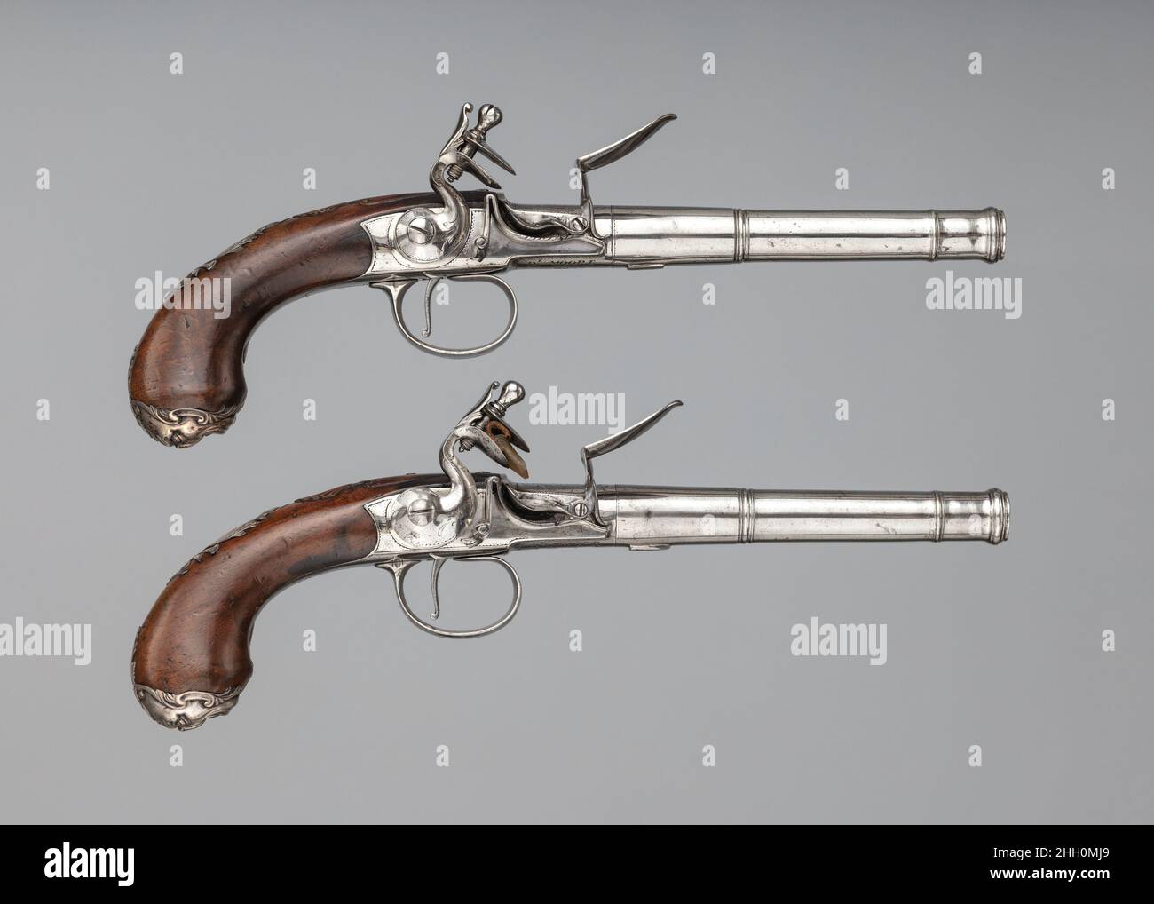 Coppia di pistole di spegnimento Flintlock ca. 1760–80 le pistole di spegnimento Daniel Moore apparvero per la prima volta intorno al 1640s e conquistarono una particolare popolarità in Inghilterra nel 18th secolo. Le canne delle pistole di spegnimento si svitano davanti alla camera, consentendo di posizionare la palla direttamente, piuttosto che caricarla attraverso la muso. Una sfera caricata tramite il sistema di spegnimento potrebbe essere leggermente più grande di una sfera caricata con muso poiché non era necessario renderla una dimensione che passerebbe facilmente attraverso il cilindro durante il caricamento. Potrebbe inserirsi nel foro più strettamente, e quindi ottenere velocità e accu aumentati Foto Stock