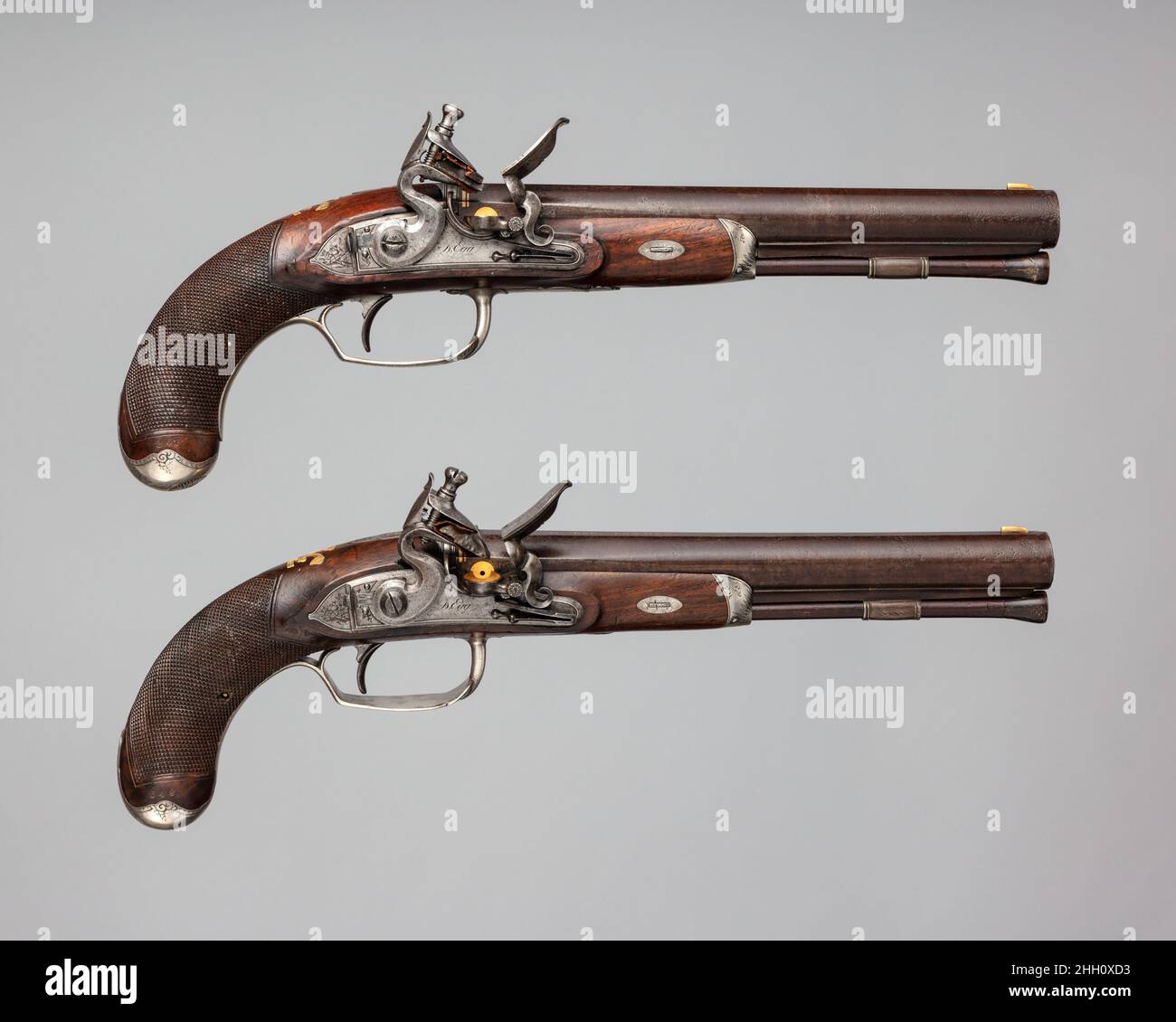 Coppia di pistole Flintlock del Principe di Galles, più tardi Giorgio IV (1762–1830) con allarmamenti inglesi DURS Egg 1793–94 realizzati per il Principe di Galles di solito presentano la sua cresta distintiva, tre piume di struzzo e una coronetta reale, E motto, ICH DIEN (io servire), intarsiato in oro o argento sul magazzino. Decorate con supporti in argento inciso, queste pistole reali hanno un piccolo pezzo di piombo incorporato all'interno dell'impugnatura, aggiunto da Egg come controbilanciamento alla canna e per dare l'erpito dell'arma da fuoco. La protezione a grilletto piatta e lunga con una barra all'estremità anteriore è una caratteristica regolare dell'ovaio DURS Egg Foto Stock