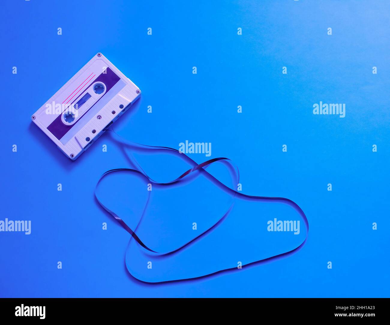 Retro con una cassetta audio srotolata su sfondo blu. Organizzazione di una festa musicale. Vintage, design retrò. Poster design. Foto Stock