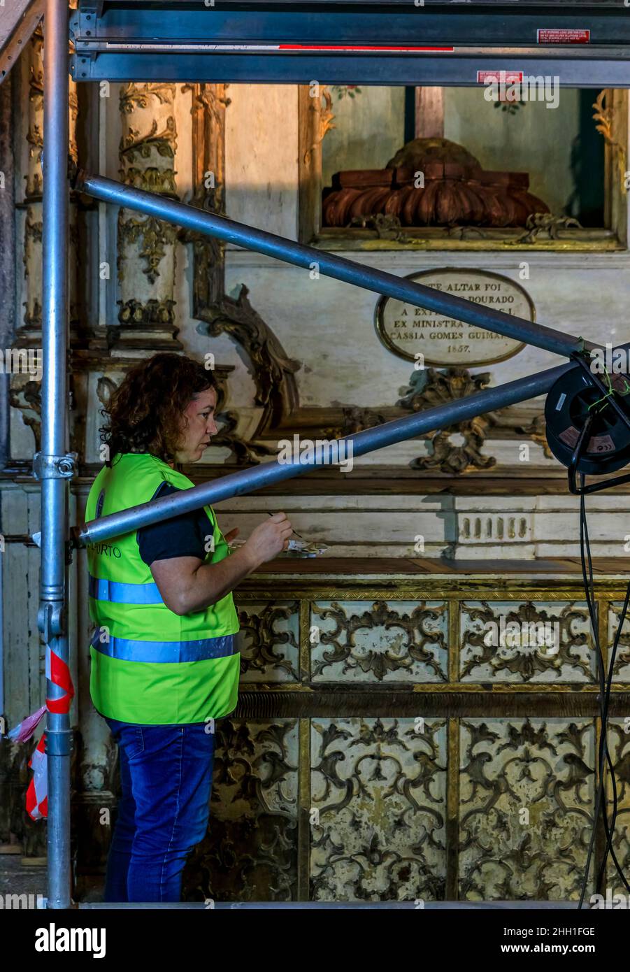 Porto, Portogallo - 30 maggio 2018: Restauratore femminile di conservatori che lavora all'interno della Chiesa del Monumento Francescano di San Francesco del 14th secolo Foto Stock
