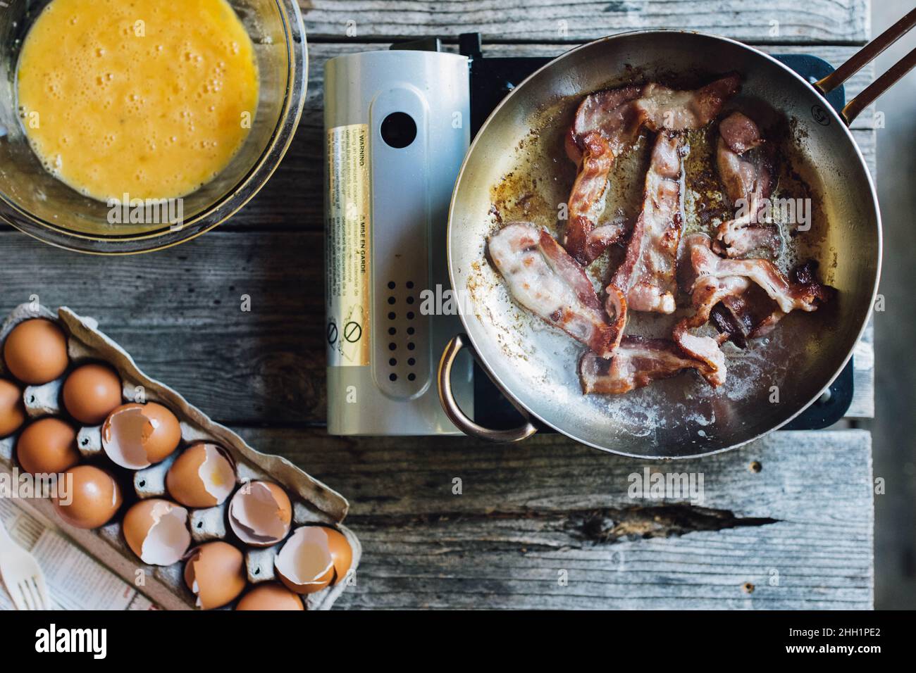 la colazione è servita al piano superiore con uova, conchiglie, pancetta sul fornello Foto Stock