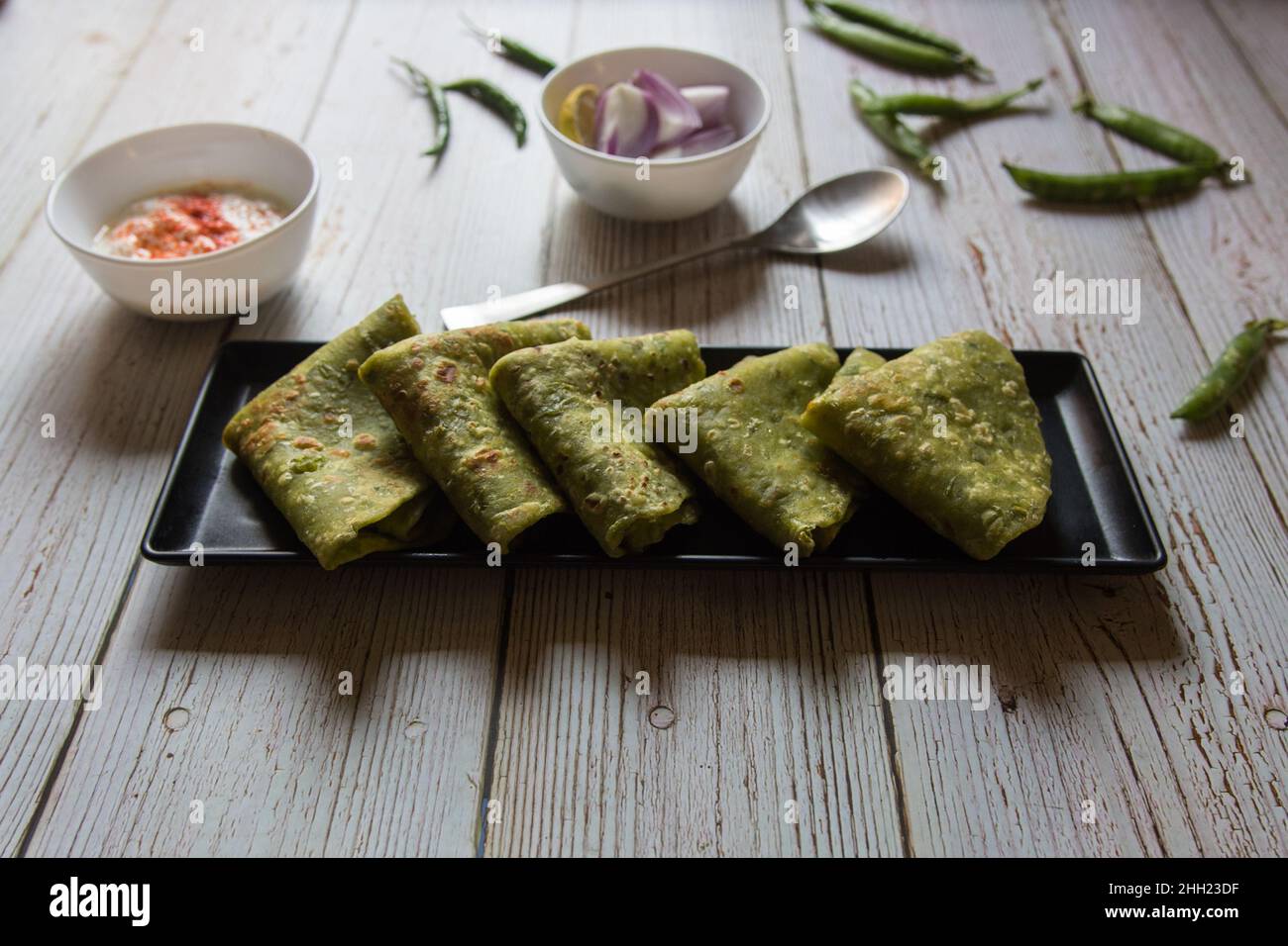 Vengono serviti piselli verdi ripieni di pane piatto indiano o matar ka paratha. Primo piano. Foto Stock