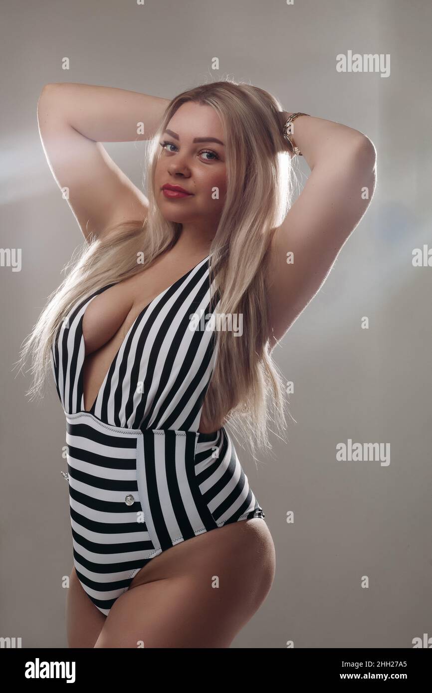 Bella donna bionda che indossa un costume da bagno bianco e nero Foto Stock