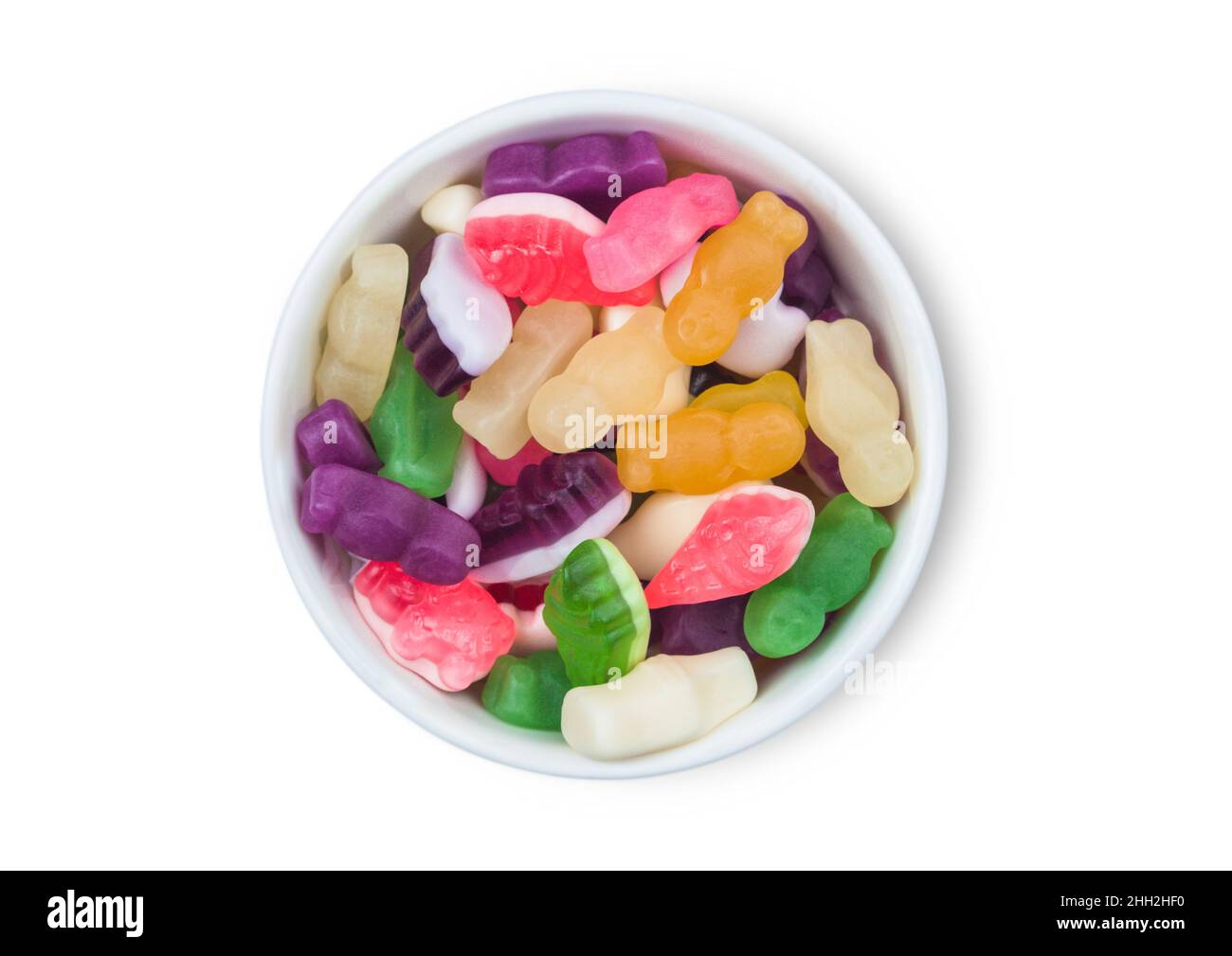 Varie caramelle di gengive multicolore in ciotola di ceramica bianca su sfondo bianco. Vista dall'alto. Foto Stock