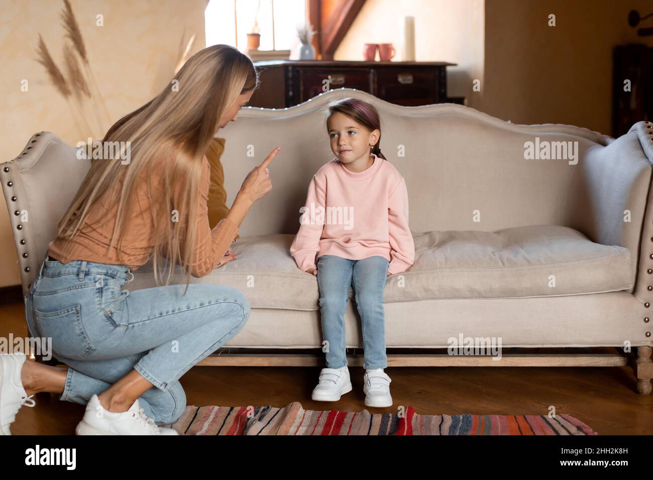 Conflitto di famiglia. Madre arrabbiata che spaventa figlia triste Foto Stock