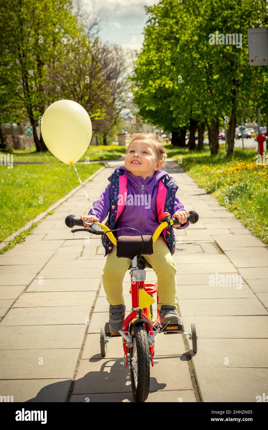 Felice 3 anni ragazza in bicicletta Foto Stock