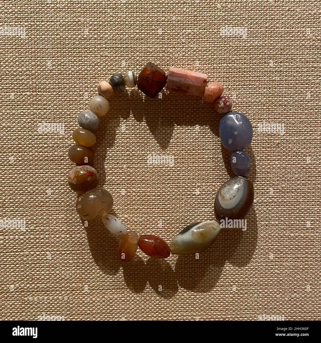 Beads 9th–12th secolo questo oggetto fu scavato a Nishapur.Nishapur era una città vitale nel periodo islamico iniziale e medio, situata lungo una delle traiettorie principali che collegavano l'Iran e le terre islamiche dell'Asia occidentale con l'Asia centrale e la Cina. Questi itinerari sono spesso indicati con il termine ‘percorsi Silk’, ma sono stati di fatto cruciali per il movimento di costellazioni di materiali e oggetti, nonché di persone e idee. La diversa popolazione di Nishapur e dei suoi dintorni, dai gruppi d'élite meglio ricercati di mercanti, aristocrazia proprietaria e letterati, all'arte meno conosciuta Foto Stock