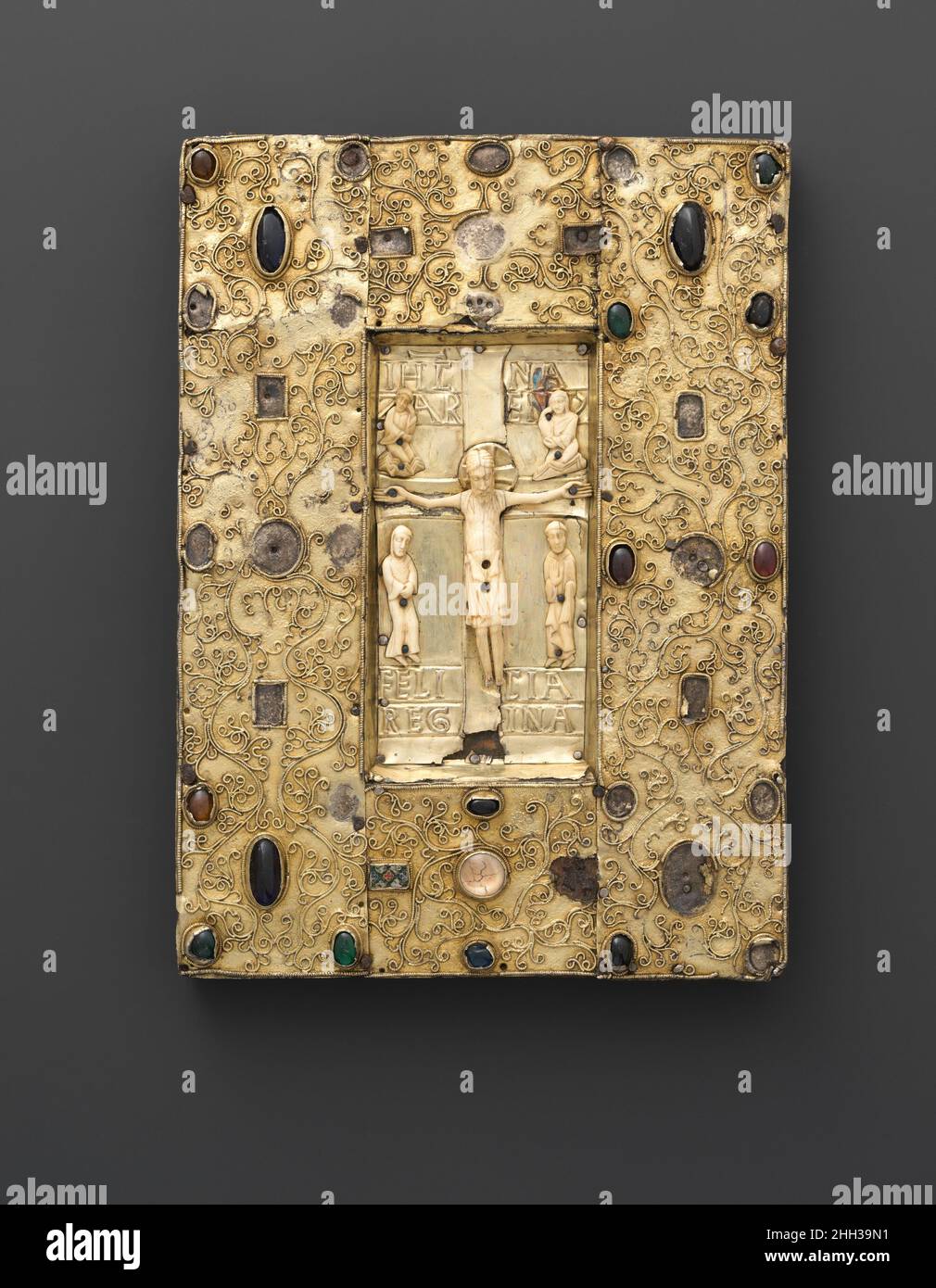 Pannello con una Crocifissione Ivory scena fine 11th secolo spagnolo questo pannello originariamente potrebbe essere servito come la sontuosa copertina di un libro sacro. Incorporando una varietà di materiali costosi e raffinate tecniche artistiche, rappresenta il tipo di lussuoso lavoro multimediale molto apprezzato dal popolo medievale. Mentre molti degli ornamenti in pietra, vetro e smalto che un tempo abbellivano la cornice sono stati persi, la scena centrale della Crocifissione sopravvive per lo più intatta, comprendente figure di avorio scolpite individualmente contro un supporto di argento dorato dominato dalla croce. Gesù, il più grande e più volumetr Foto Stock