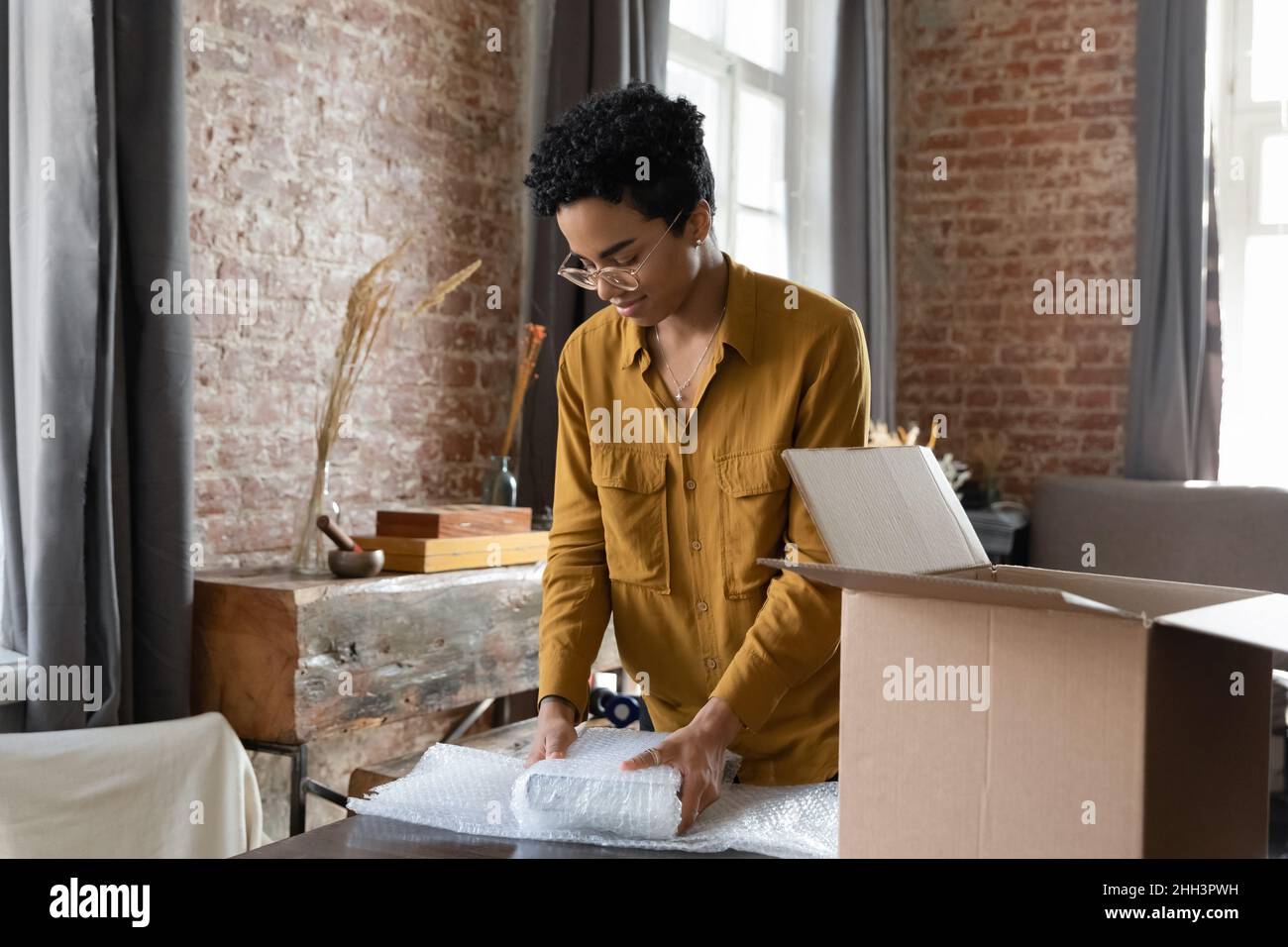 Giovane dipendente logistico afroamericano donna imballaggio merci Foto Stock