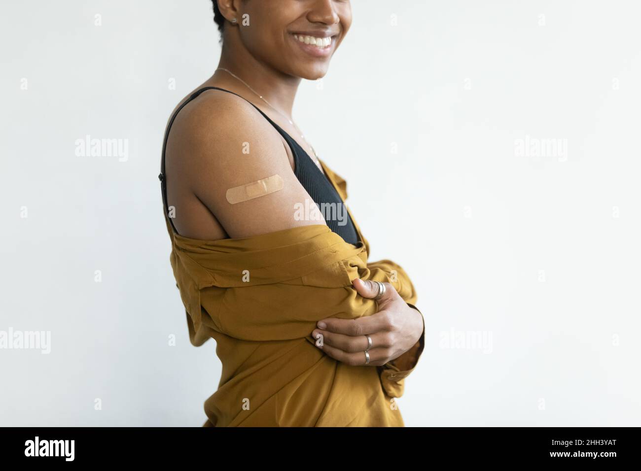 Felice Afro American signora mostrando spalla con cerotto adesivo Foto Stock