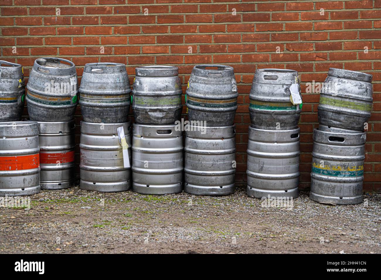 Barili di birra di metallo accatastati fuori di un pub inglese lettura per la raccolta Foto Stock