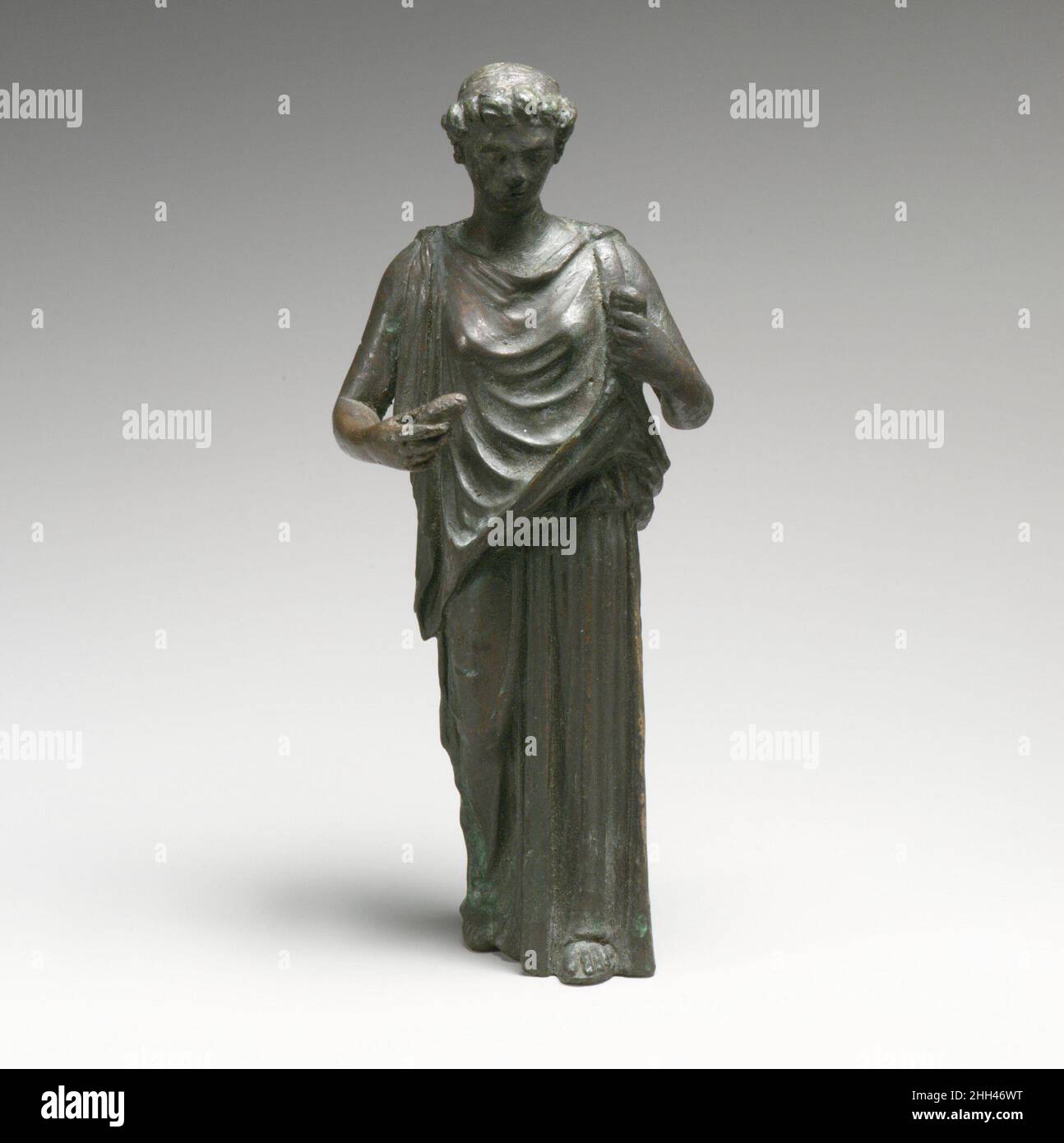 Statuette di bronzo di una donna, forse un Hesperid 2nd secolo d.C. in piedi romano, tenendo in mano i drappeggi; una copia romana di un originale greco. Statuette di bronzo di una donna, forse un Hesperid 252927 romano, statuette di bronzo di una donna, forse un Hesperid, 2nd secolo d.C., Bronzo, H. 7 5/8 in. (19,4 cm). Il Metropolitan Museum of Art, New York. Fletcher Fund, 1927 (27.122.12) Foto Stock