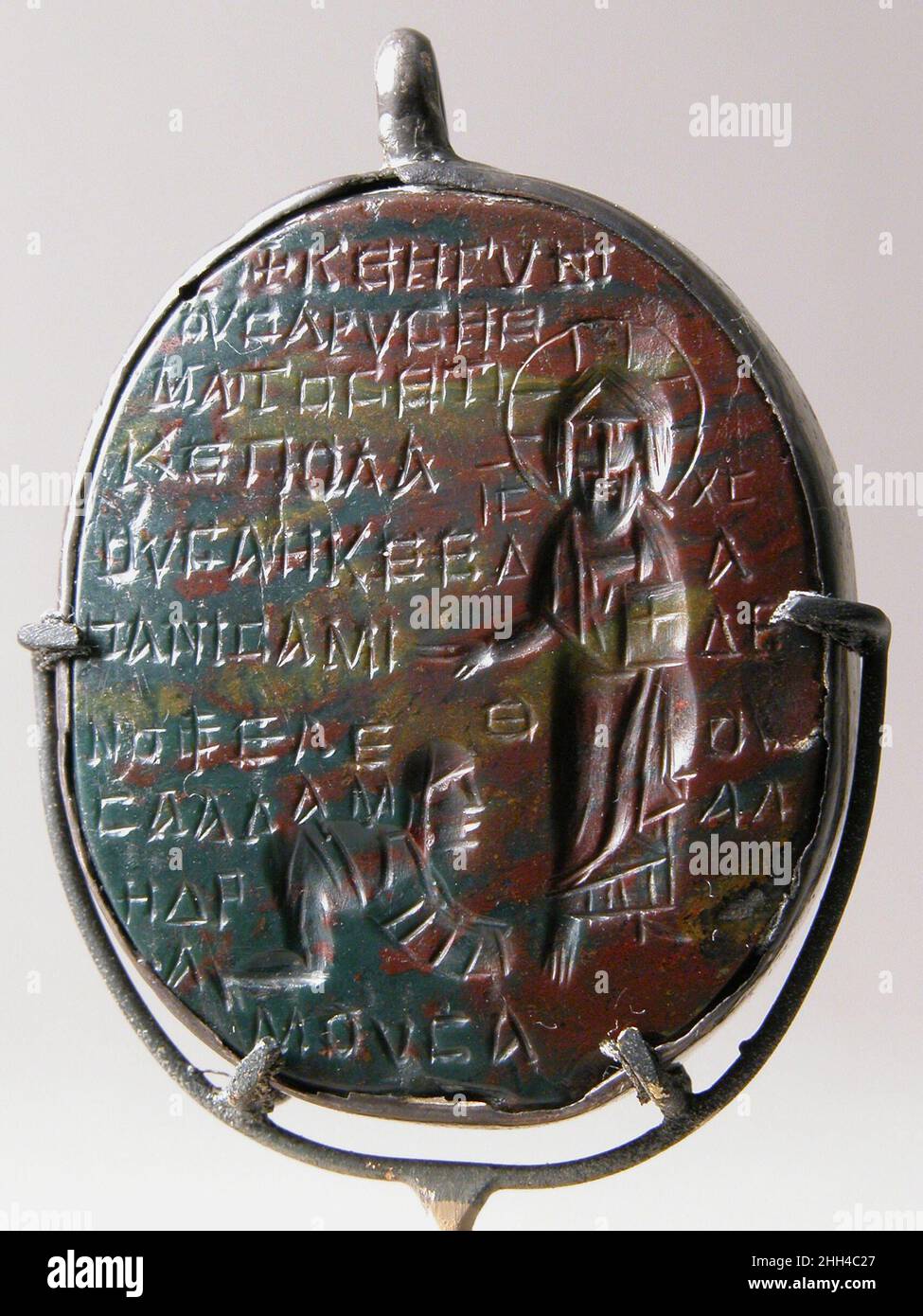 Amuleto scolpito in intaglio (incisa) 6th–7th secolo le iscrizioni copte identificano il soggetto di questo amuleto come la Donna con il numero di sangue (Marco 5:25–34; Luca 8:43–48). Al contrario una donna si trova nella posa dell'orante (preghiera). L'ematite era creduta per arrestare il flusso di sangue ed era un mezzo favorito per amuleti relativi alla salute riproduttiva femminile e ai problemi mestruali. Amuleto intagliato in intaglio (incisa). Copto. 6th–7th secolo. Ematite, supporto argento. Prodotto in Egitto bizantino. Lavoro lapidario-ematite Foto Stock